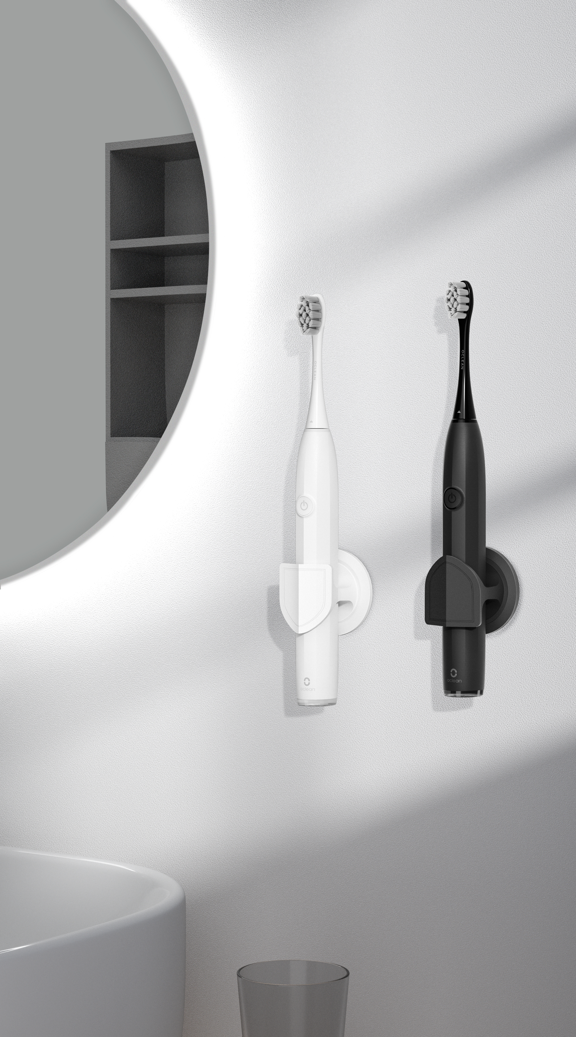 Dwie elektryczne szczoteczki do zębów na uchwytach, biała i czarna, zamontowane na ścianie obok lustra.