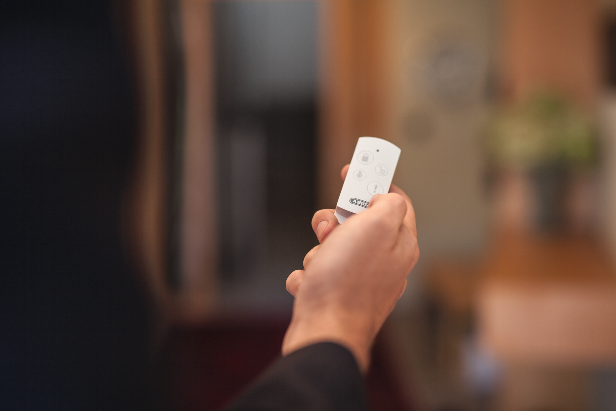 Una mano che tiene un telecomando bianco con pulsanti.