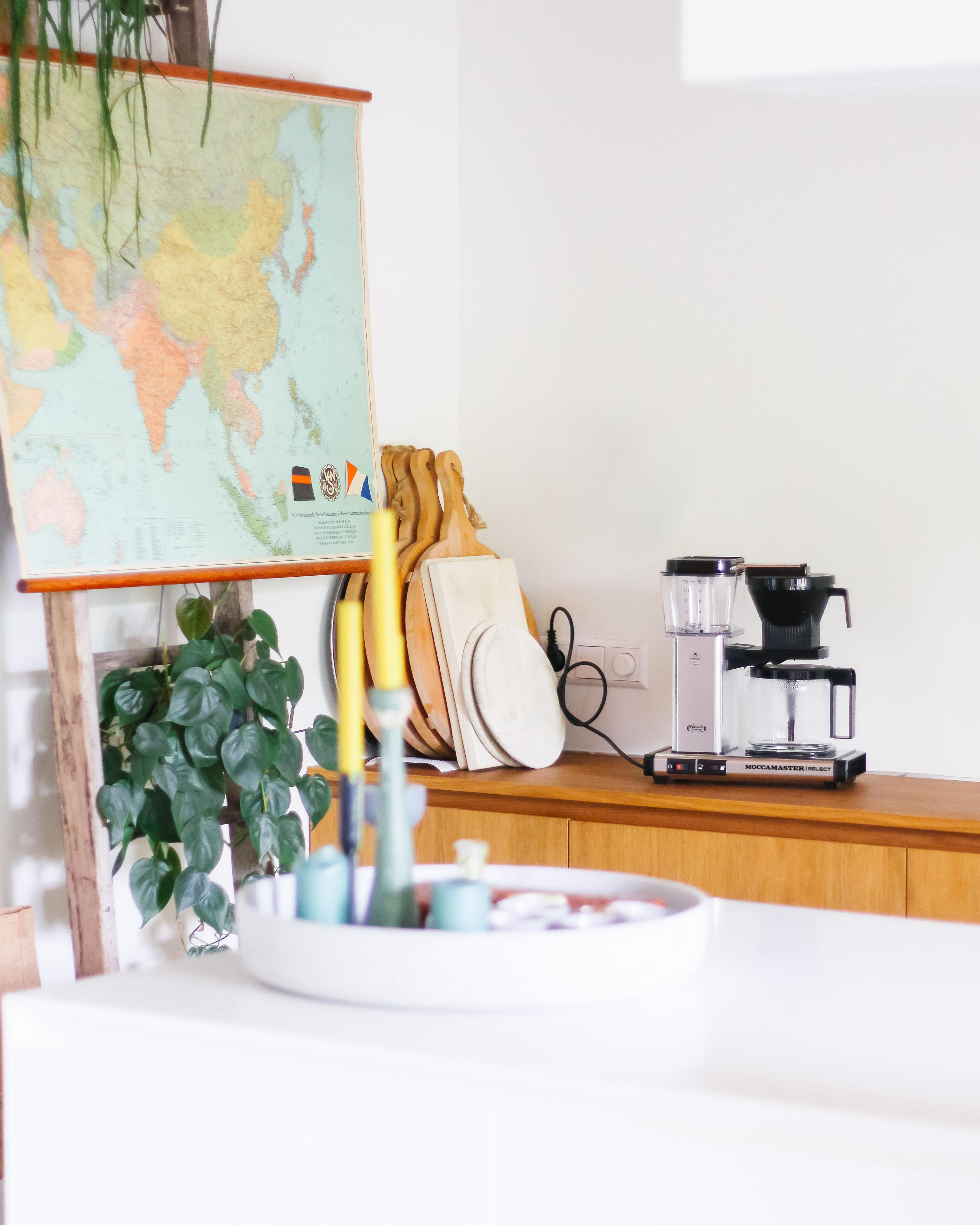 Scena kuchenna: mapa, deski do krojenia, ekspres do kawy i taca z przedmiotami.