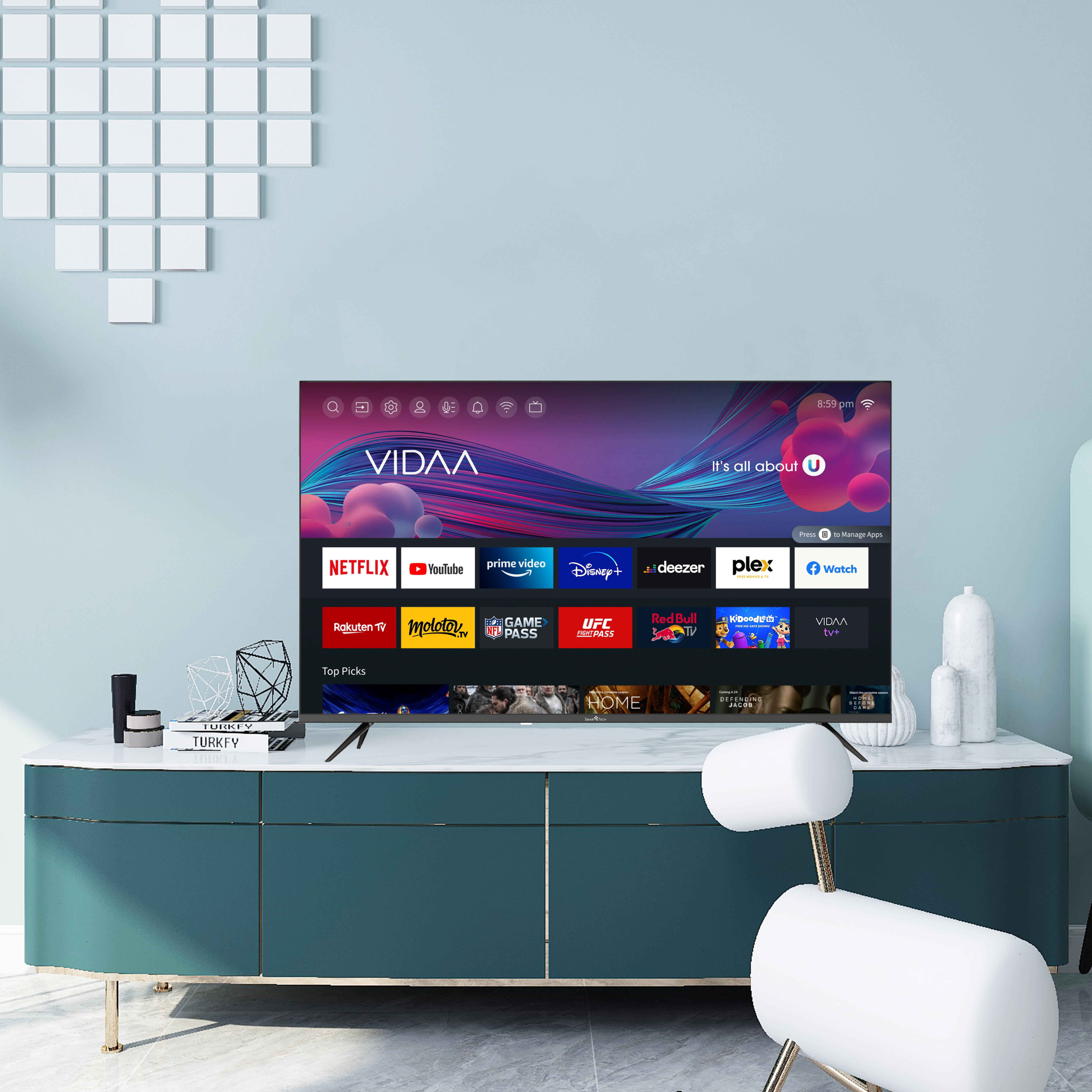 Telewizor z dużym ekranem wyświetlający kolorową grafikę, ustawiony na turkusowej szafce z dekoracjami.