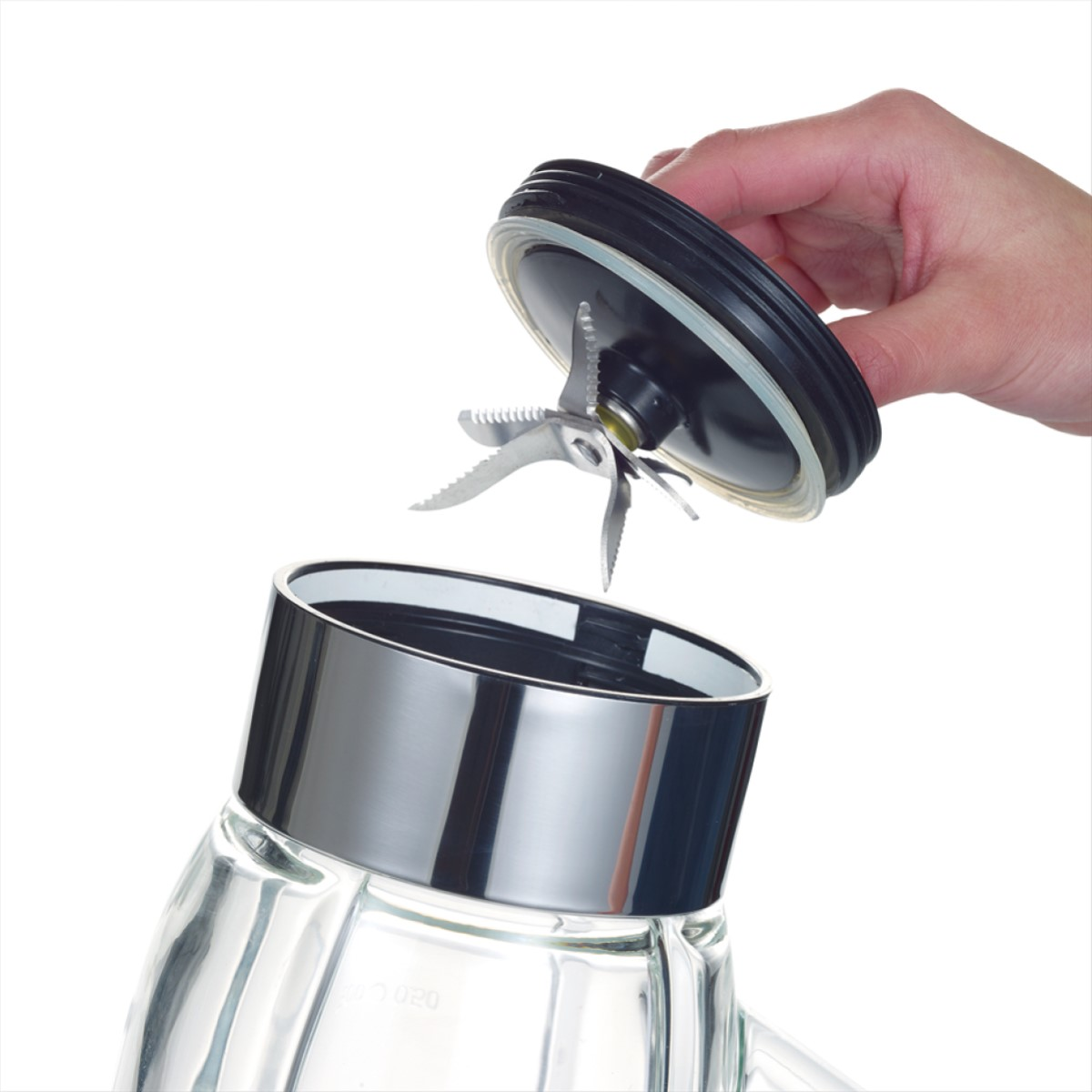 A person's hand removing a blender lid with blades. White background.