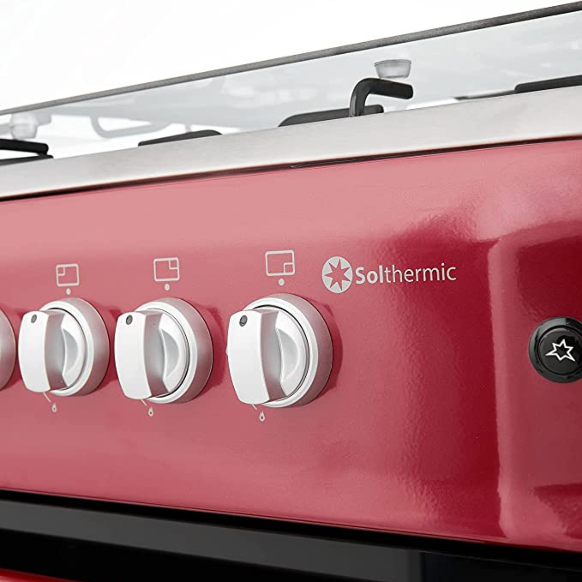 Primer plano del panel de control de una estufa roja con perillas blancas. El logotipo de Solthermics está presente.