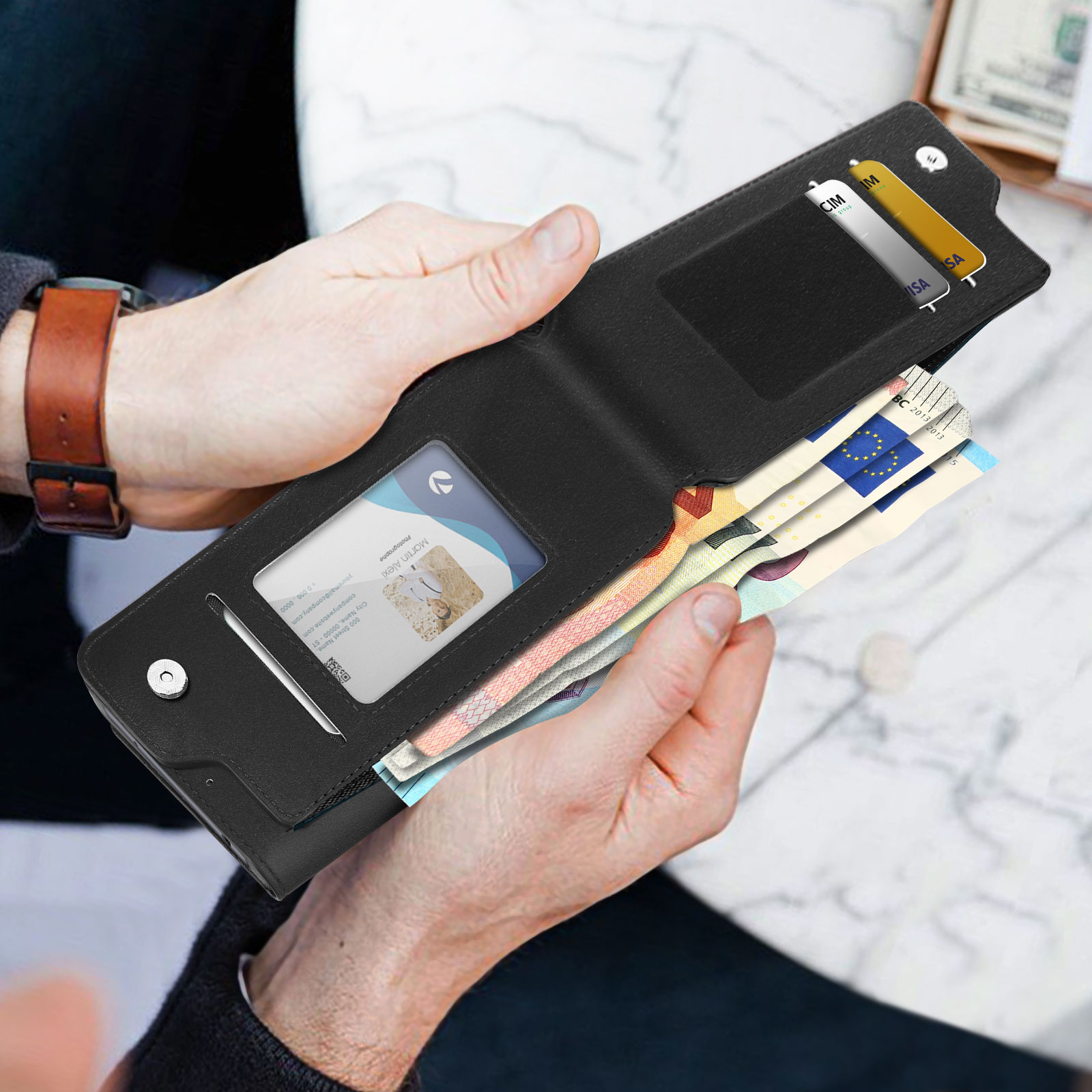 Una persona apre un portafoglio nero rivelando denaro, carte e una carta d'identità.