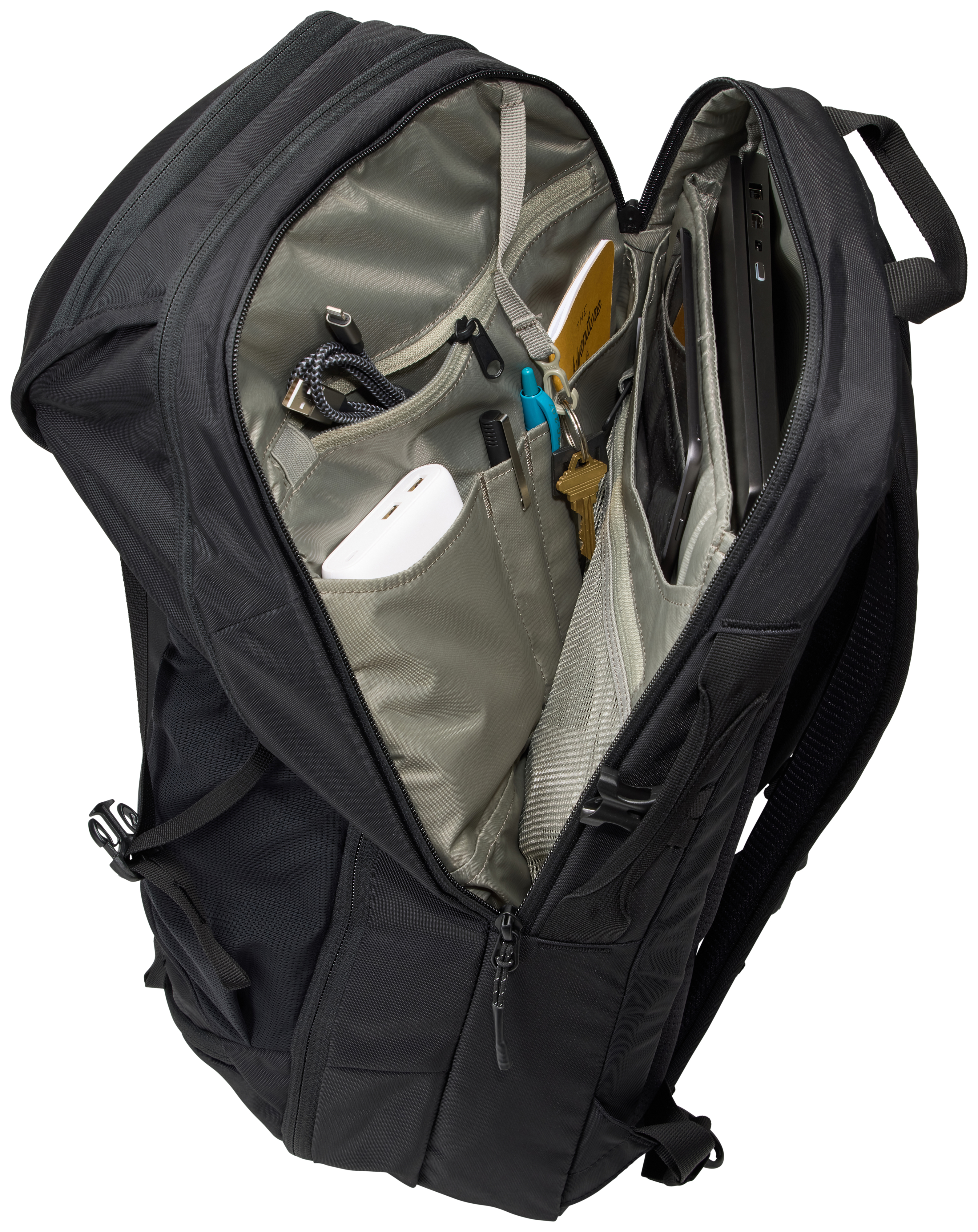 Schwarzer Rucksack, geöffnet, Fächer sichtbar. Innen Gegenstände wie Kabel und Laptop.