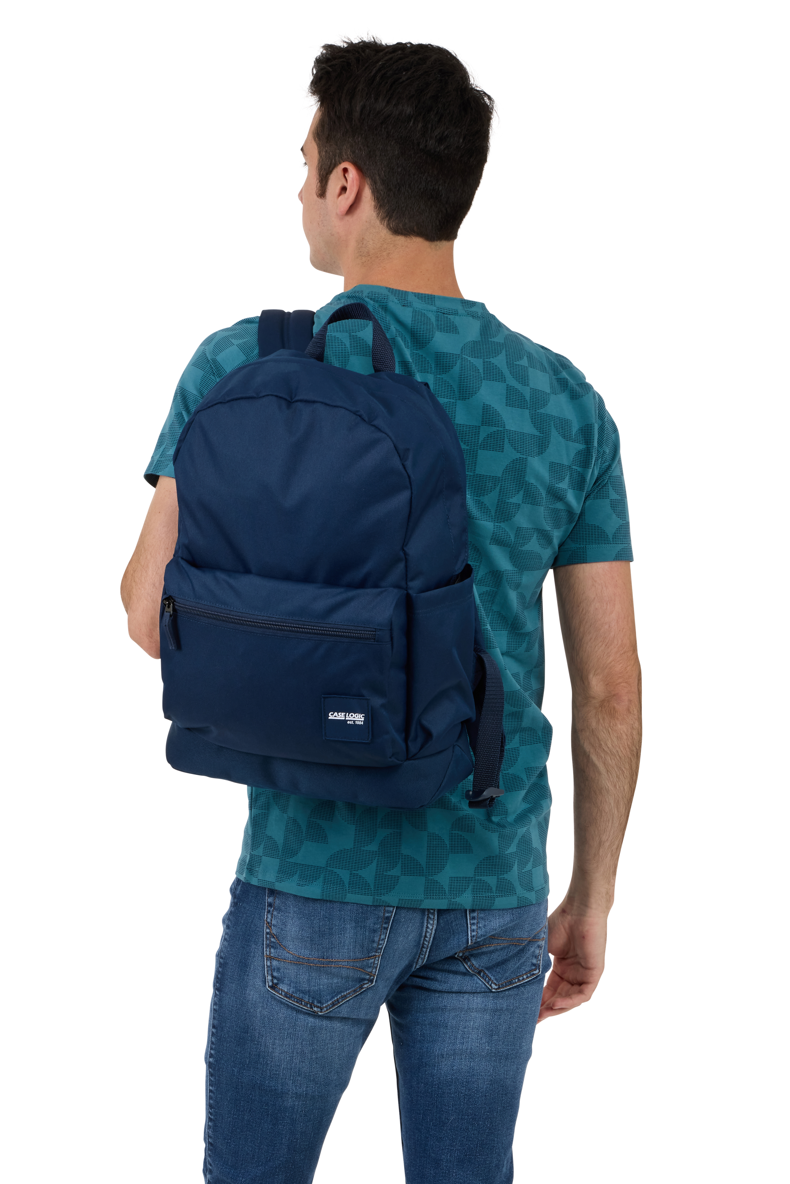 Ein Mann mit blauem Rucksack. Er trägt ein türkisblaues Hemd und Jeans.