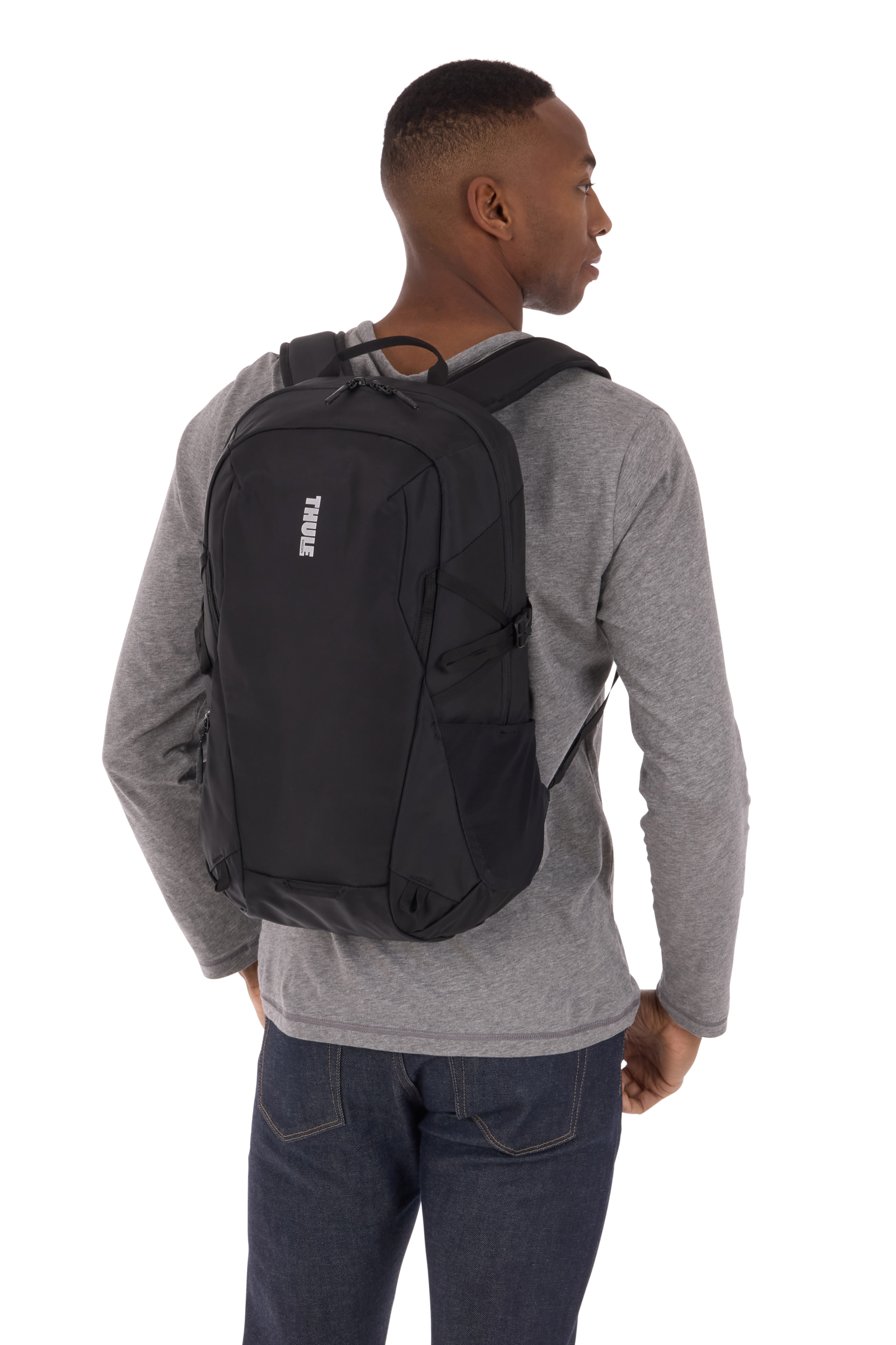 Un hombre con una mochila negra, visto desde atrás.