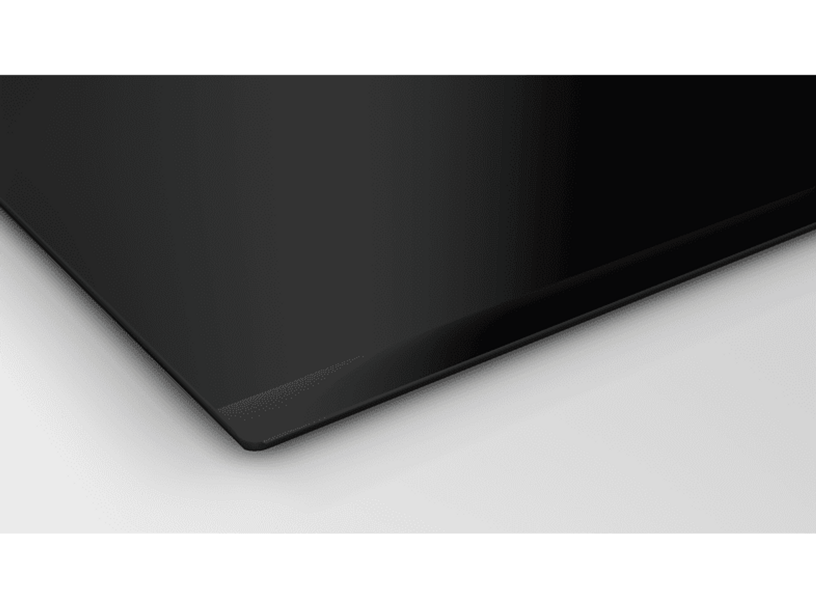 Czarna, błyszcząca powierzchnia. Powierzchnia jest lekko pochylona. Tło jest białe.