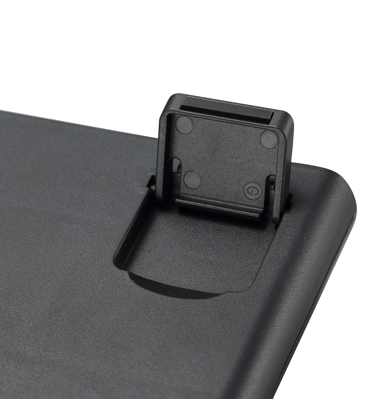 Base de teclado negra con un pequeño soporte. El soporte está abierto. Aislado sobre fondo blanco. Primer plano.