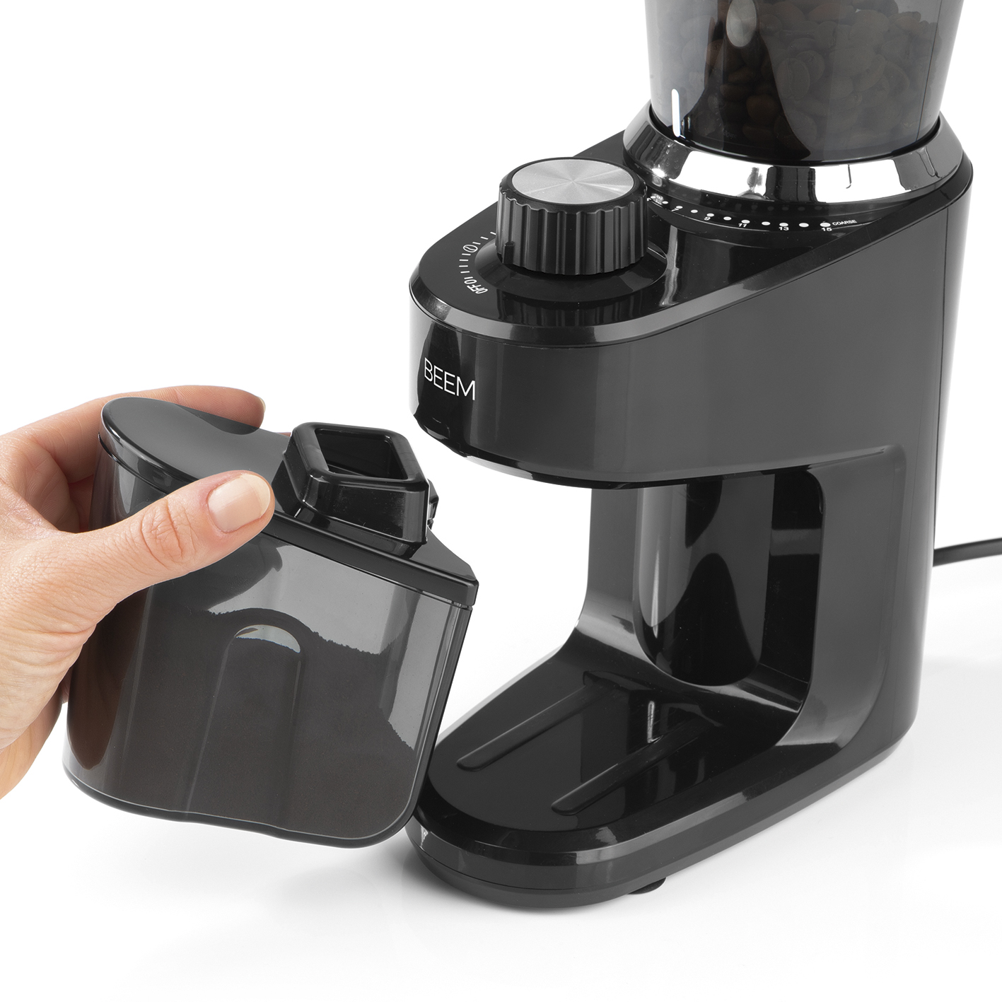 Schwarze Kaffeemühle mit einer Hand, die den Behälter für das Kaffeemehl hält, bereit zum Einsetzen.