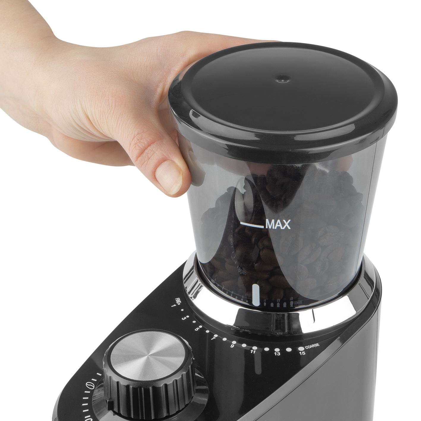 Kaffeemühle, Hand dreht den Drehknopf, Bohnen innen. Schwarz und Chrom. Weißer Hintergrund.