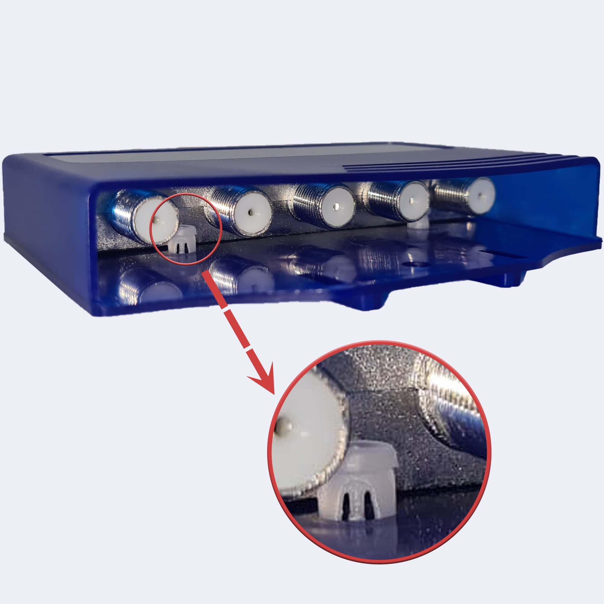 Ein blauer Splitter mit mehreren Eingängen. Ein Pfeil zeigt auf einen weißen Stecker in einem Anschluss.