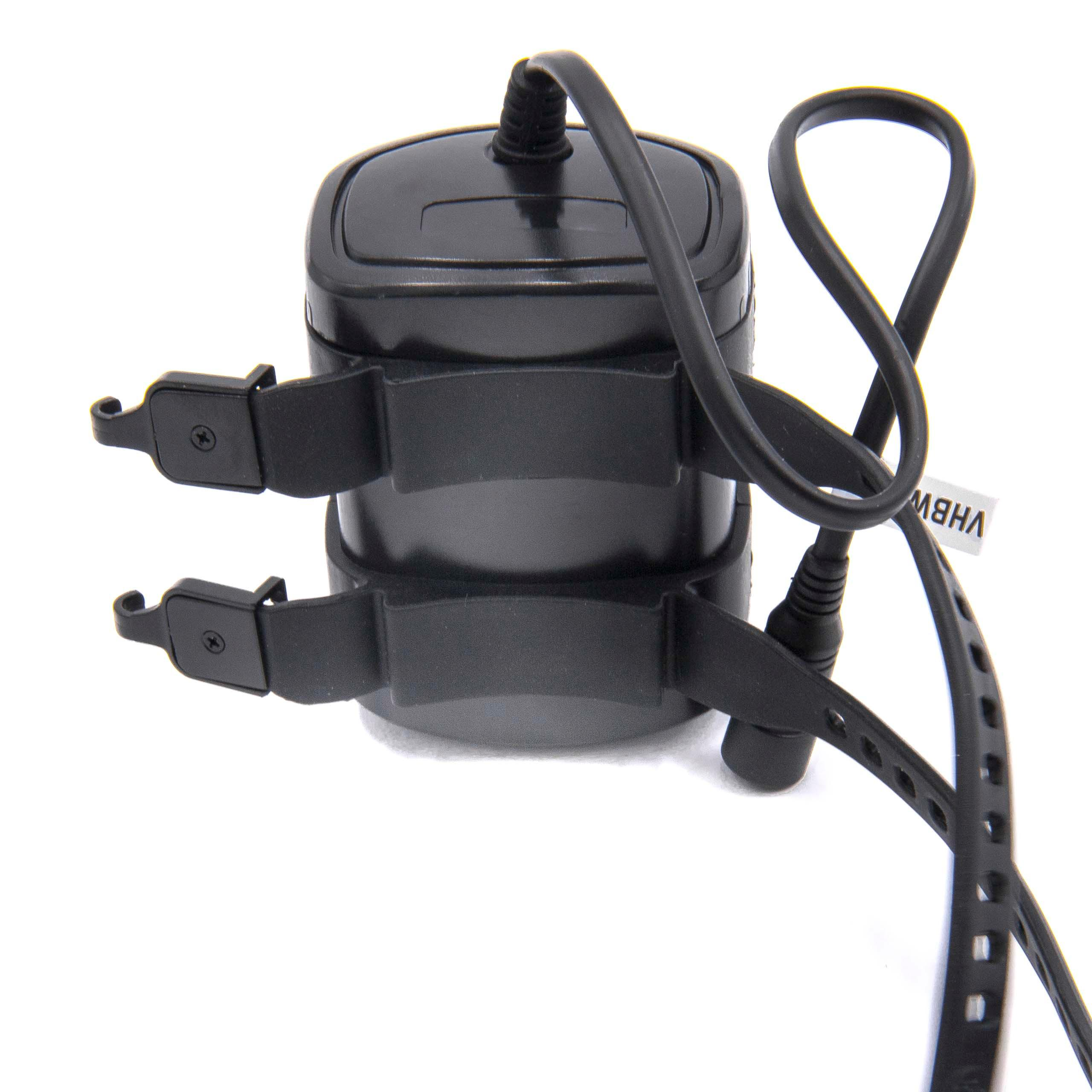 Schwarzes Gerät mit Riemen und Kabel, möglicherweise eine Batterie oder Stromquelle.