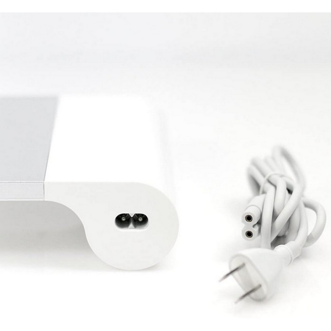 Adaptador de corriente blanco con cable blanco. El adaptador tiene dos clavijas para la toma de corriente.