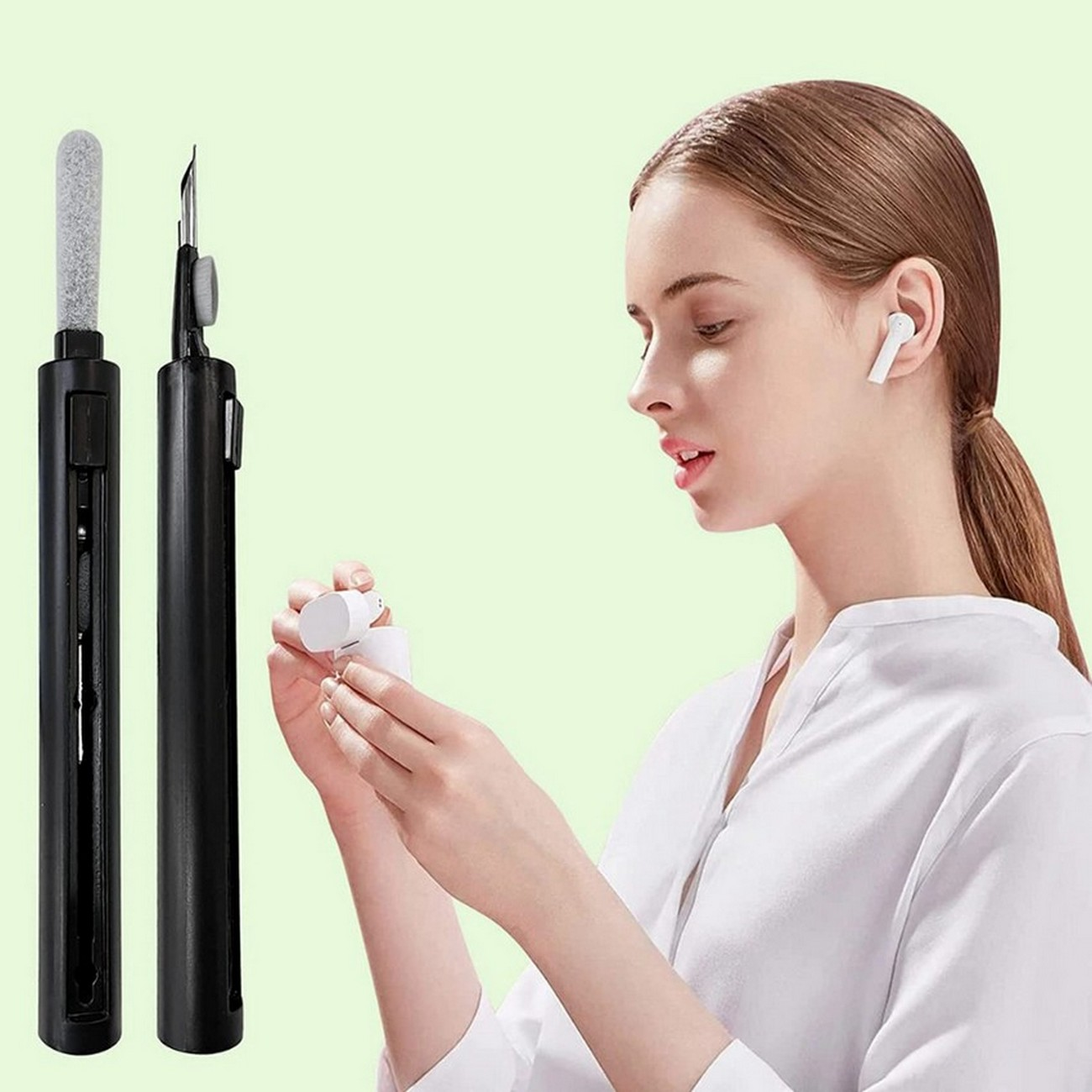 Mujer sosteniendo una herramienta de limpieza y un estuche de auriculares, fondo verde.