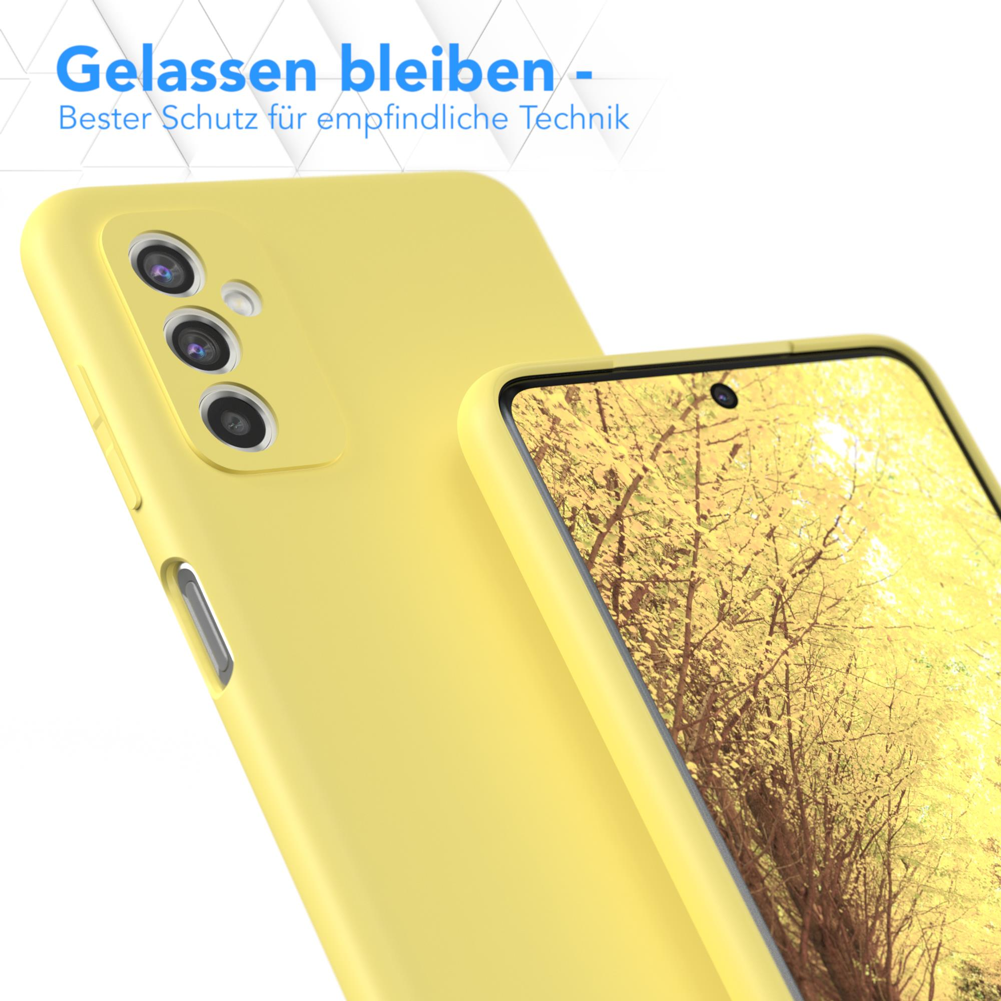 Gelbe Handyhülle mit Telefon darin. Im Hintergrund ein verschwommenes Bild von gelben Blättern.