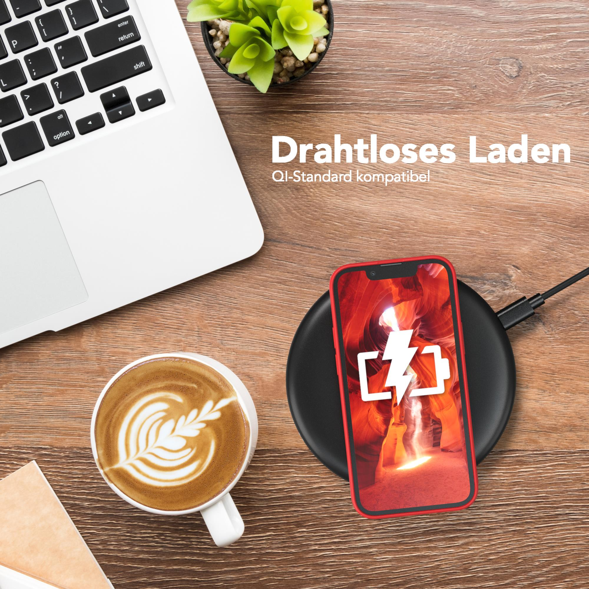 Ein Laptop, eine Kaffeetasse, ein Telefon auf einem Ladegerät und eine Pflanze.