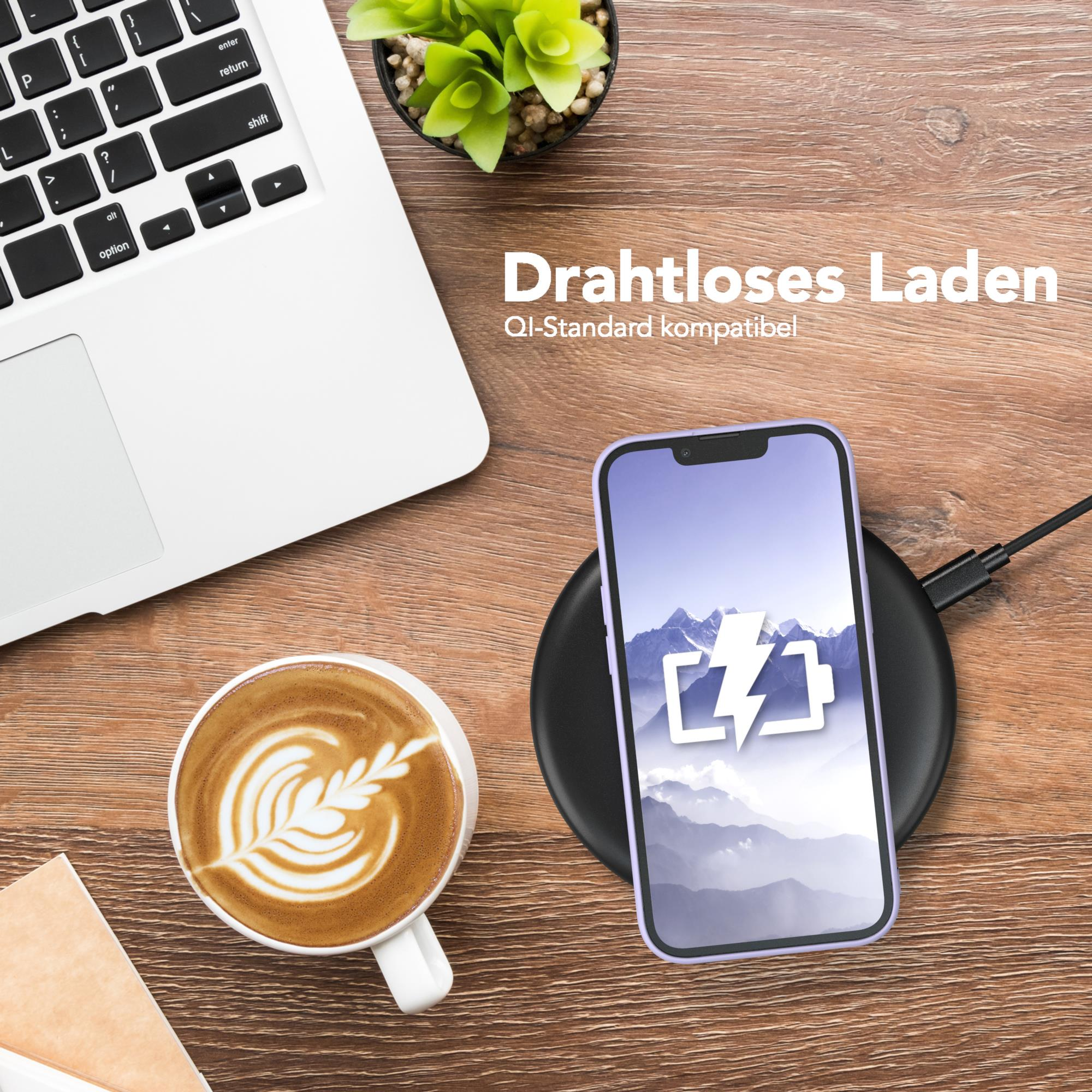 Telefon, der drahtlos auf einem schwarzen Pad neben einem Laptop und einer Kaffeetasse geladen wird.