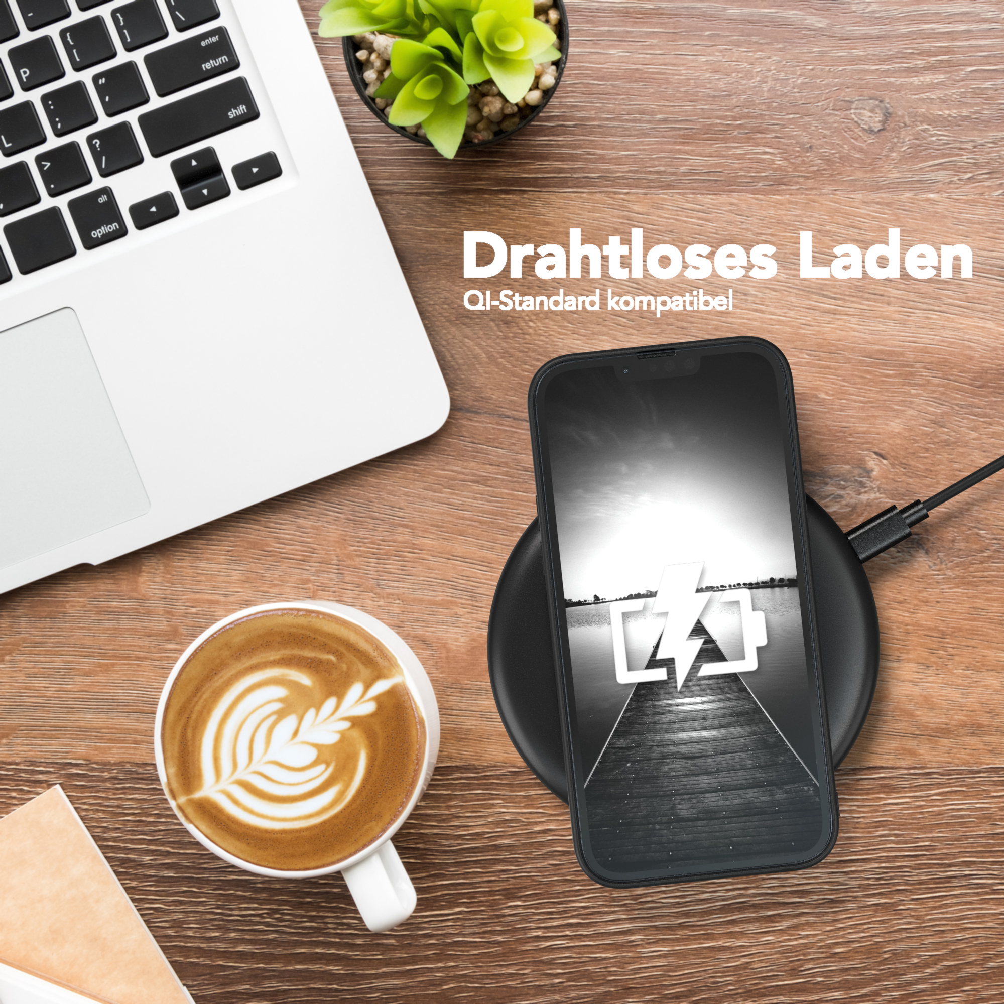 Ein Laptop, Kaffee und Telefon, das auf einem kabellosen Ladegerät auf einem Holztisch geladen wird. Deutscher Text.