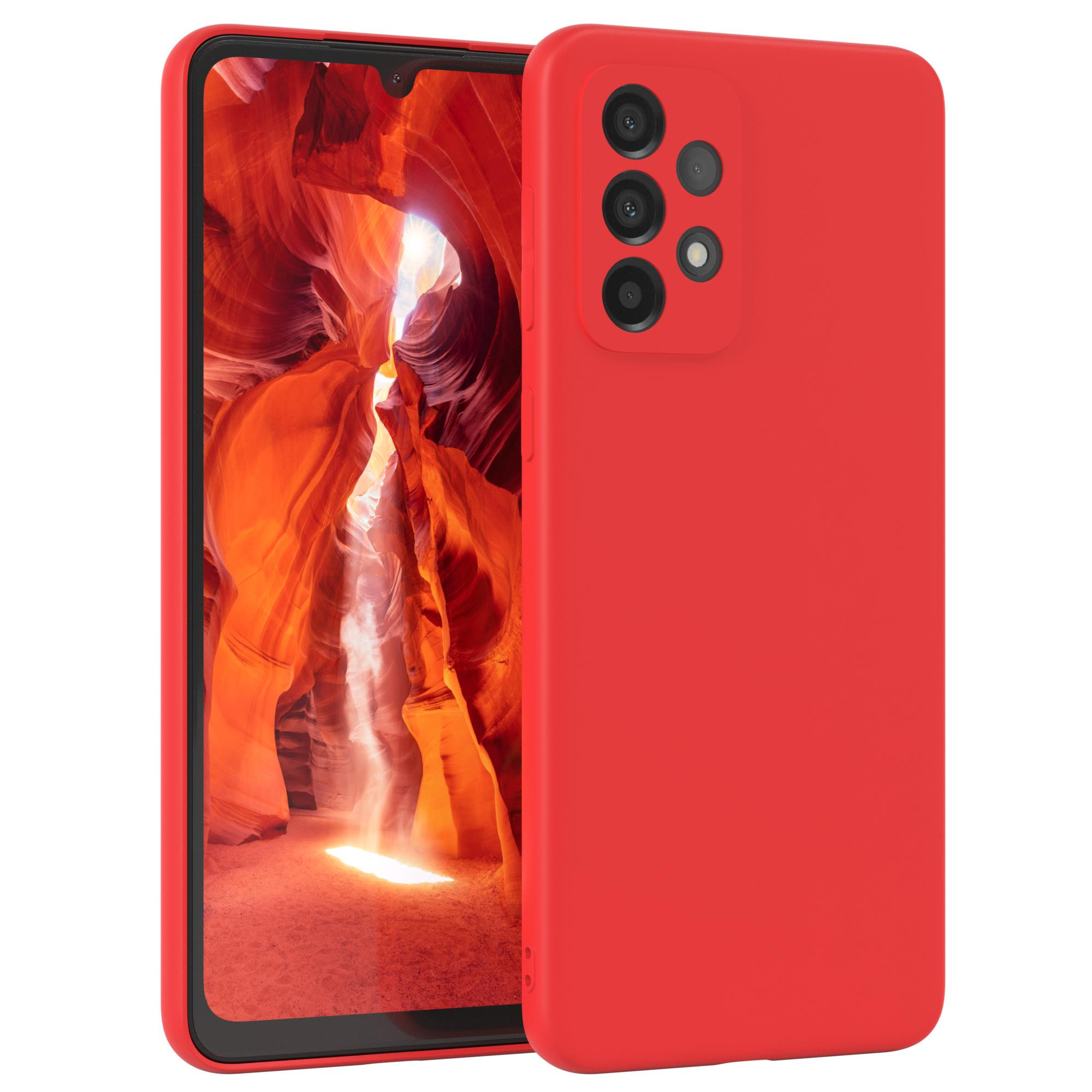 Eine rote Handyhülle neben einem Handy, das ein rotes und oranges Canyonbild zeigt.