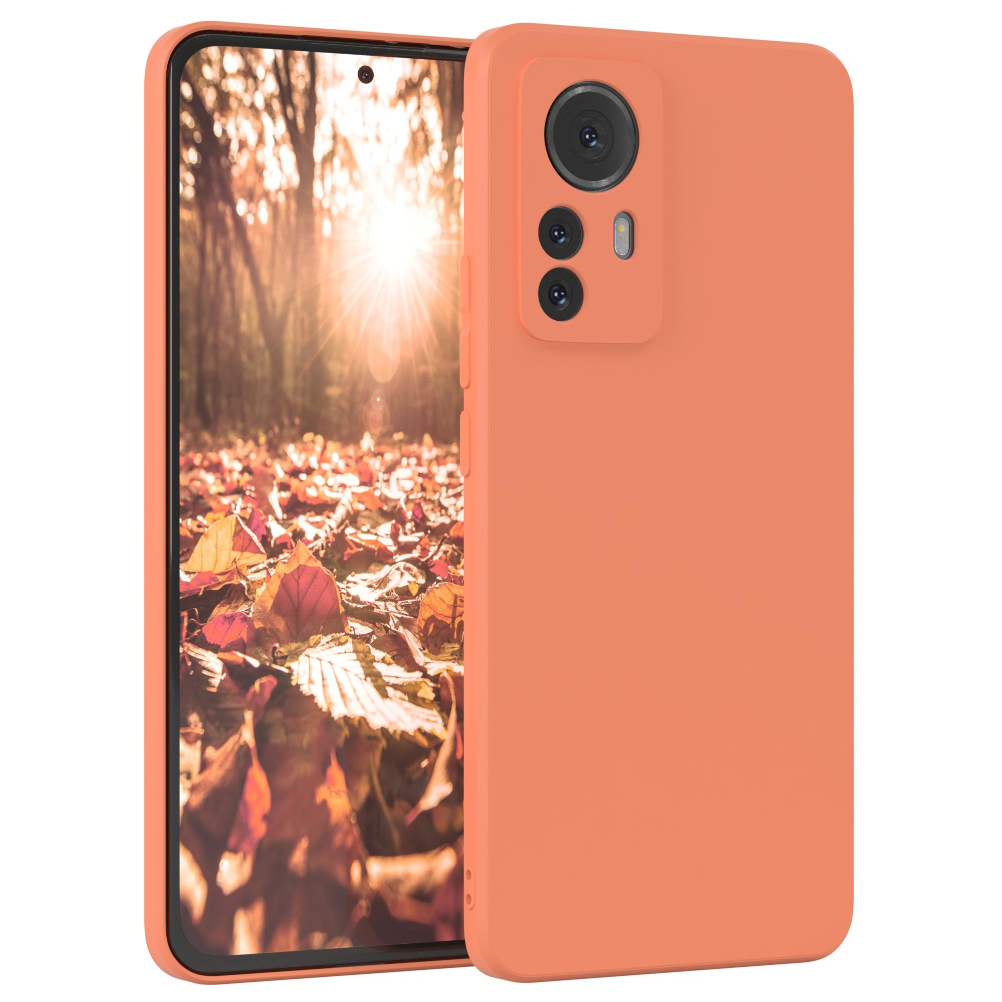 Orangefarbene Handyhülle. Der Bildschirm zeigt eine Herbstszene mit Blättern und Sonnenlicht.