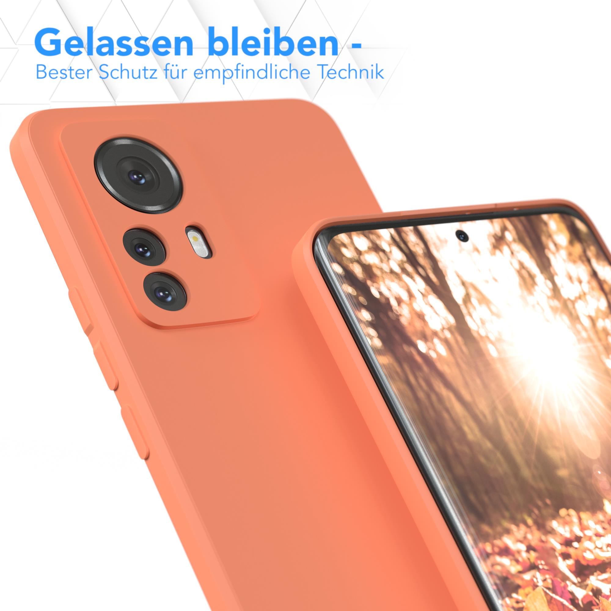 Orangene Handyhülle mit einem Telefon darin. Die Hülle hat einen Kameraausschnitt. Weißer Hintergrund.