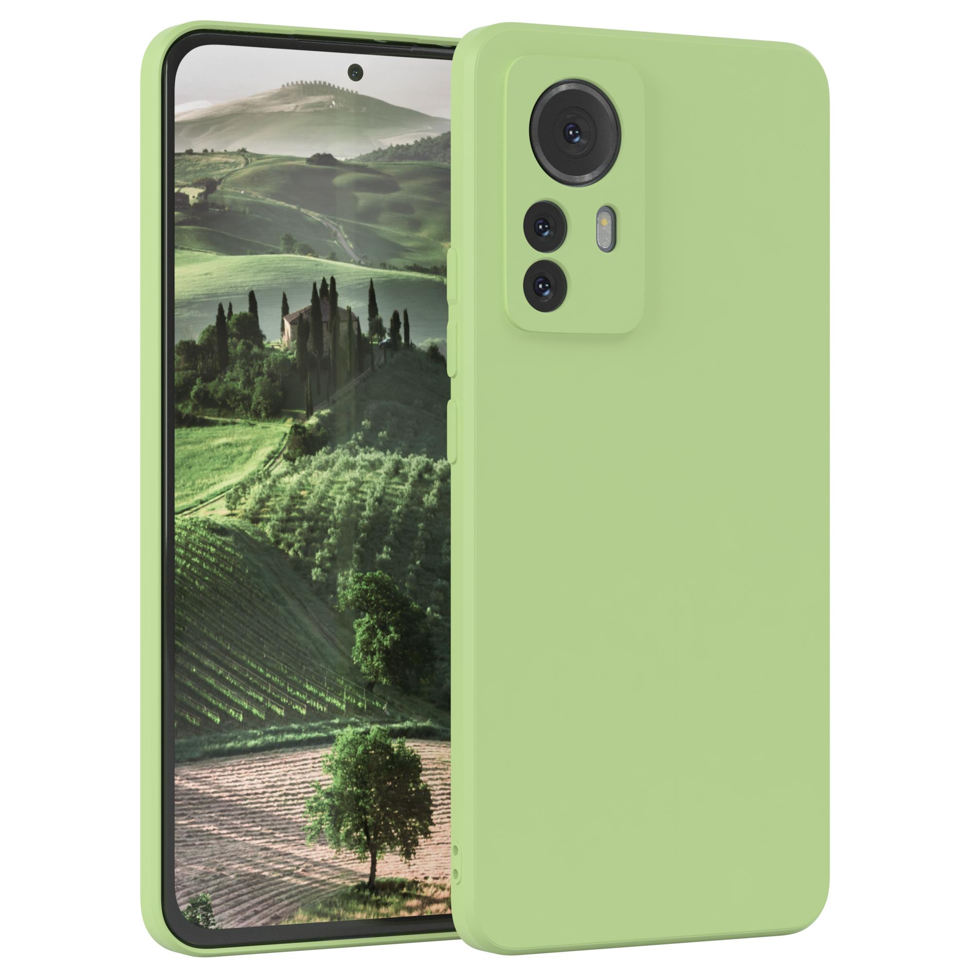 Grünes Telefon mit Hülle. Der Bildschirm zeigt eine Landschaft mit Bäumen und Hügeln.