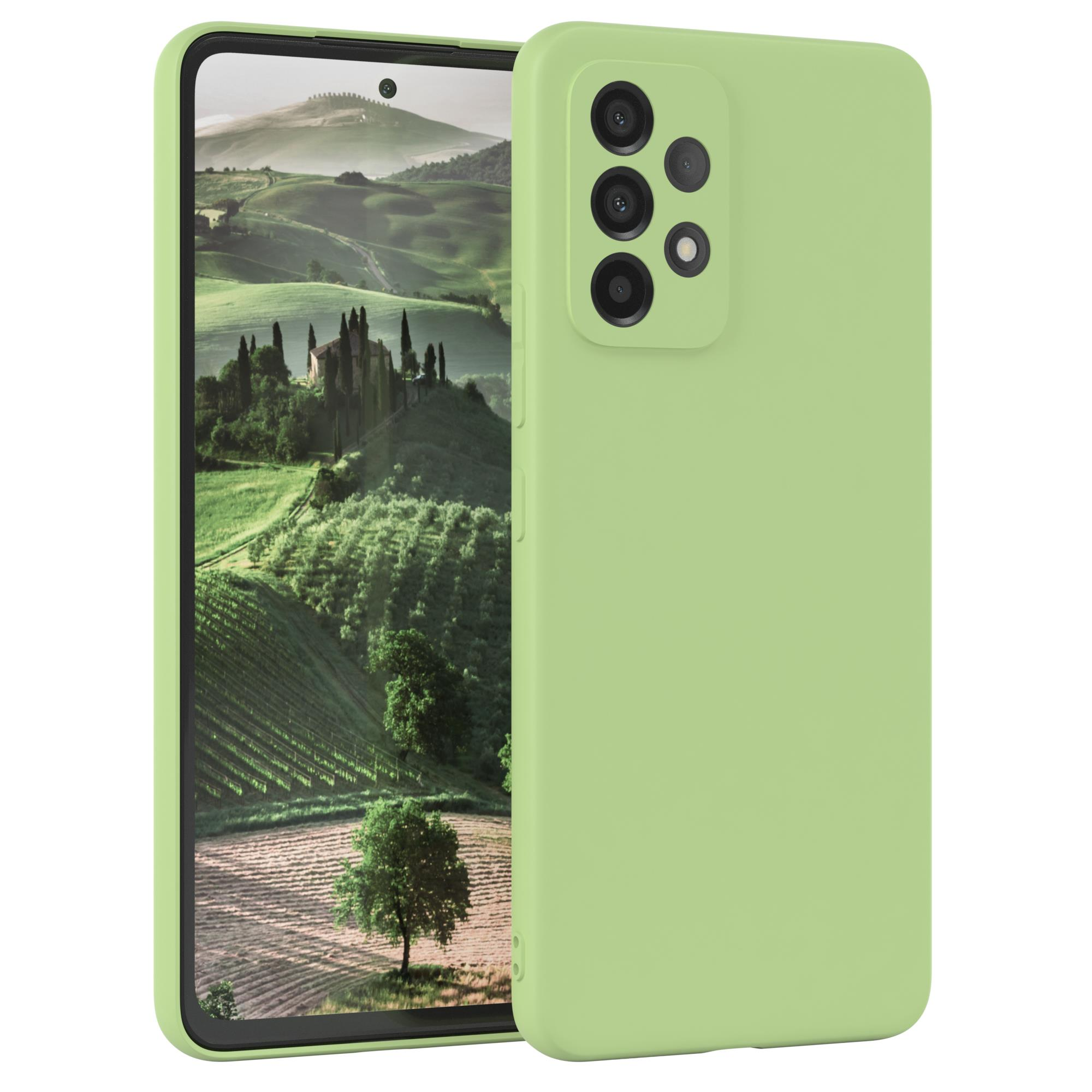 Grünes Telefon mit Hülle. Der Bildschirm zeigt eine Landschaft mit Bäumen und Hügeln.