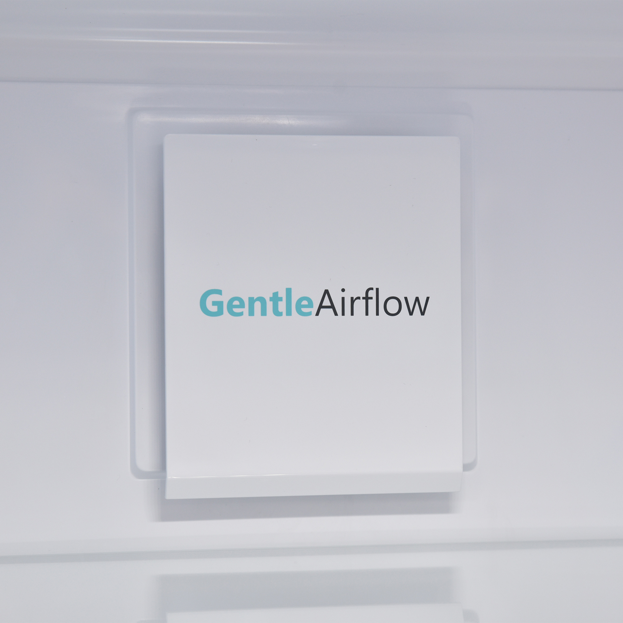 Weißes Panel mit GentleAirflow-Text in Türkis. Das Panel befindet sich in einem weißen Gerät.