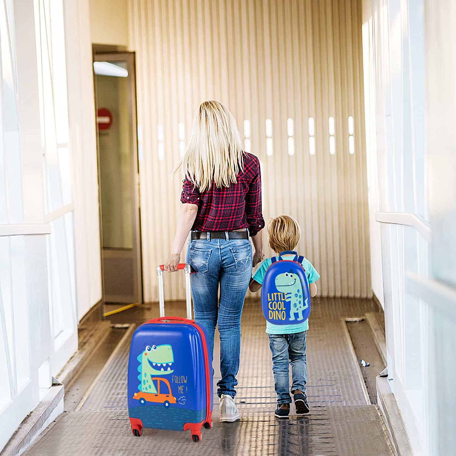 Eine Frau und ein Kind mit Koffer und Rucksack gehen in einem Flur.