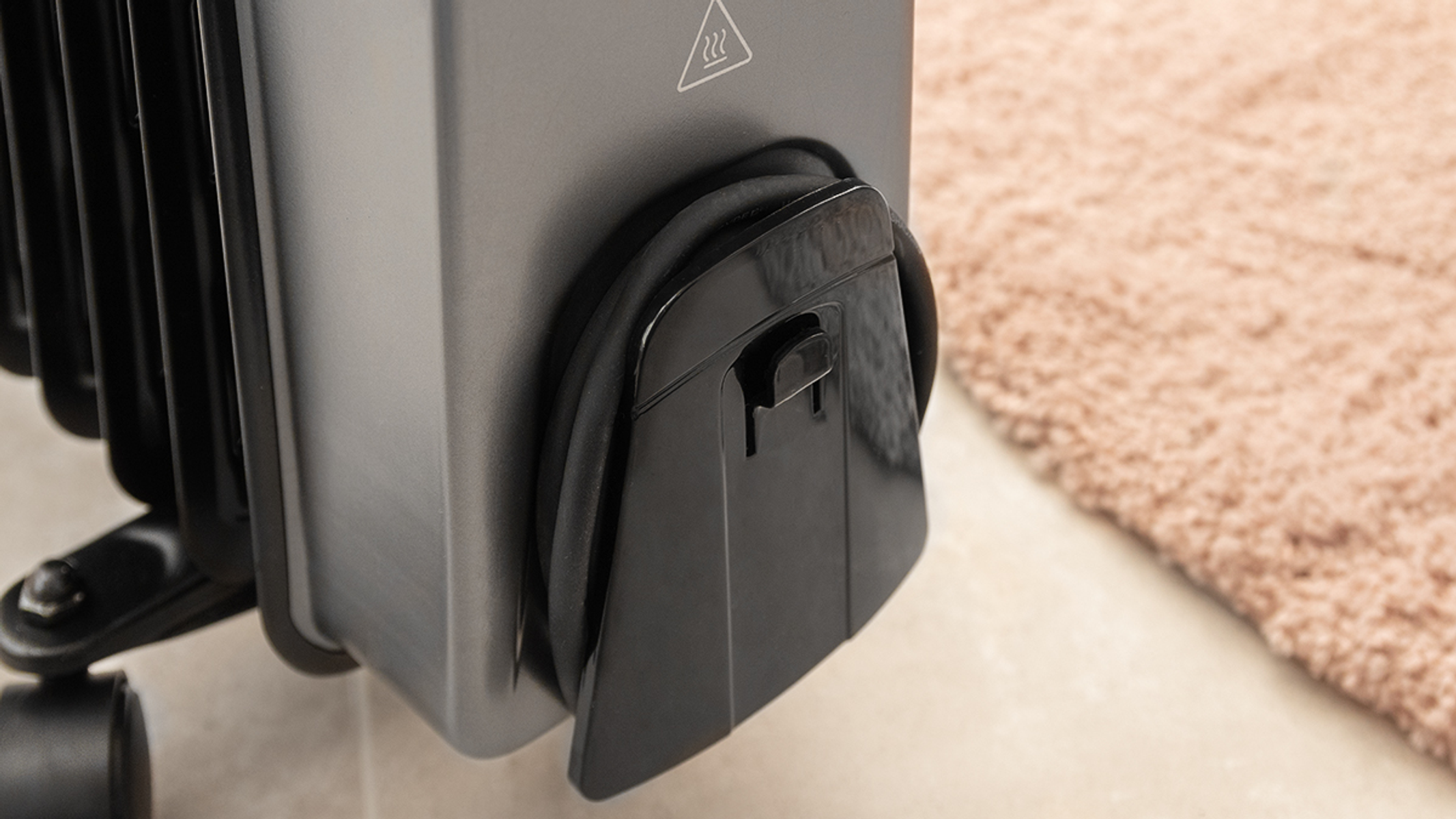 Zbliżenie na schowek na przewód czarnego grzejnika elektrycznego z uchwytem.