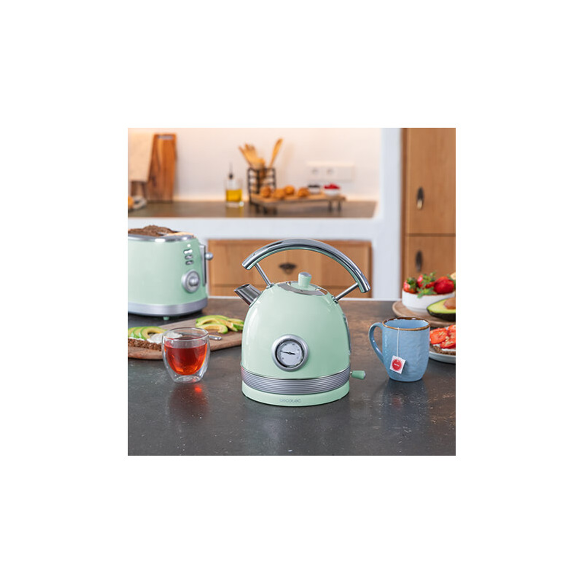 Miętowy czajnik, filiżanka herbaty i toster na stole.