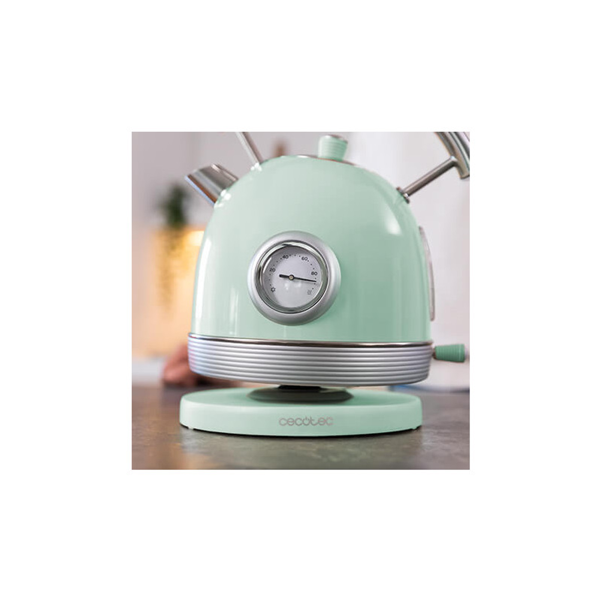 Miętowy, elektryczny czajnik w stylu retro na białym tle, ze wskaźnikiem temperatury.