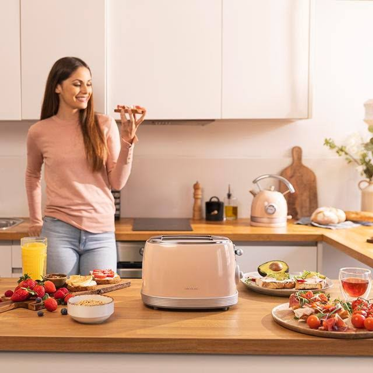 Eine Frau hält Toast, steht in einer Küche mit Toaster, Obst und anderen Lebensmitteln auf einer Theke.