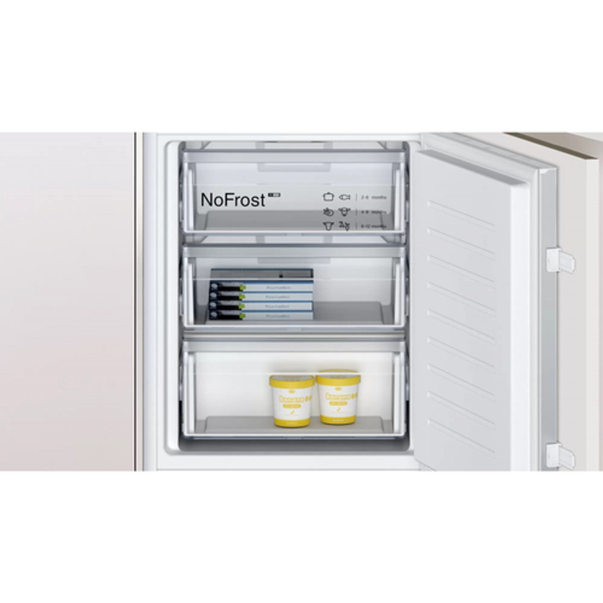 Refrigerador blanco abierto con tres cajones. Contiene recipientes y paquetes de alimentos congelados.