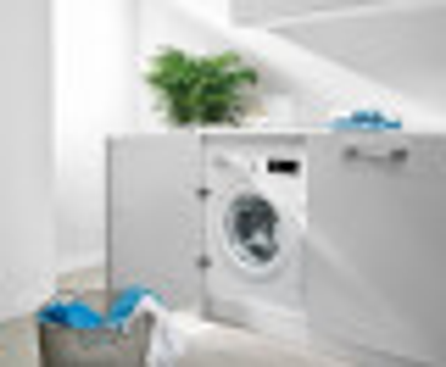 Pralka jest ukryta za białymi drzwiami. Jest kosz na pranie.