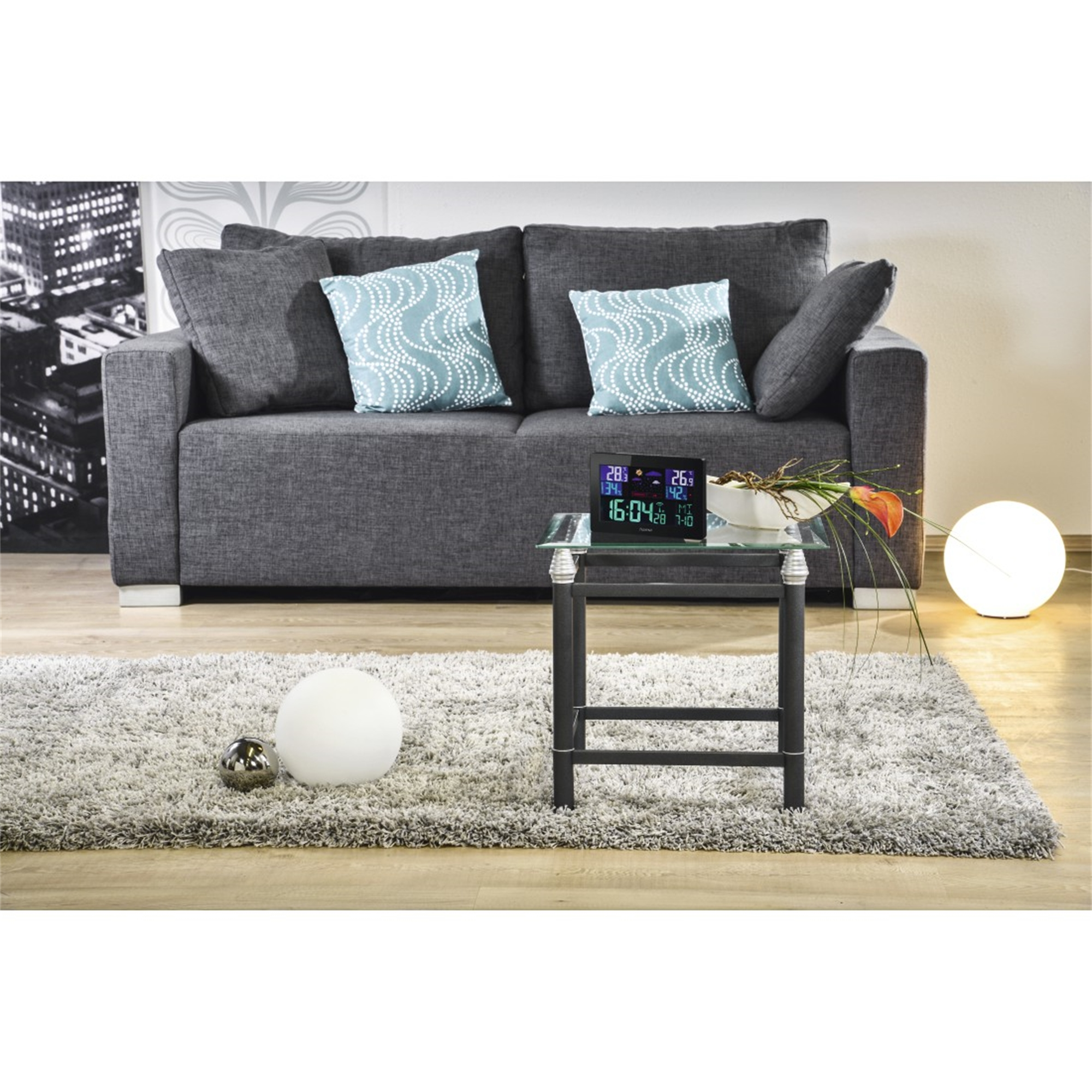 Escena de sala con sofá, alfombra, mesa y luz. Hay almohadas decorativas.