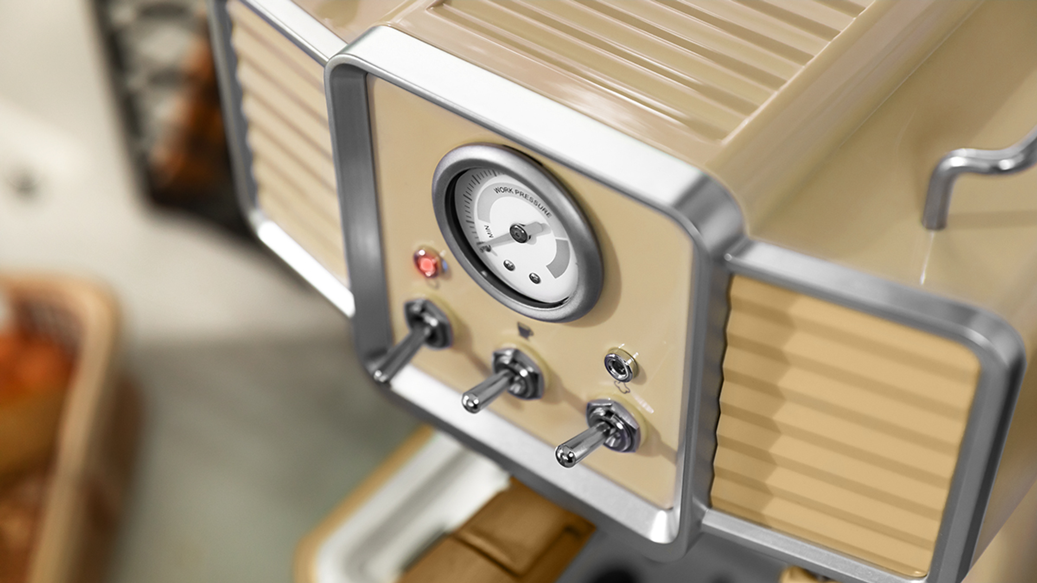 Primer plano de una máquina de café vintage con medidores, interruptores y diseño color crema.