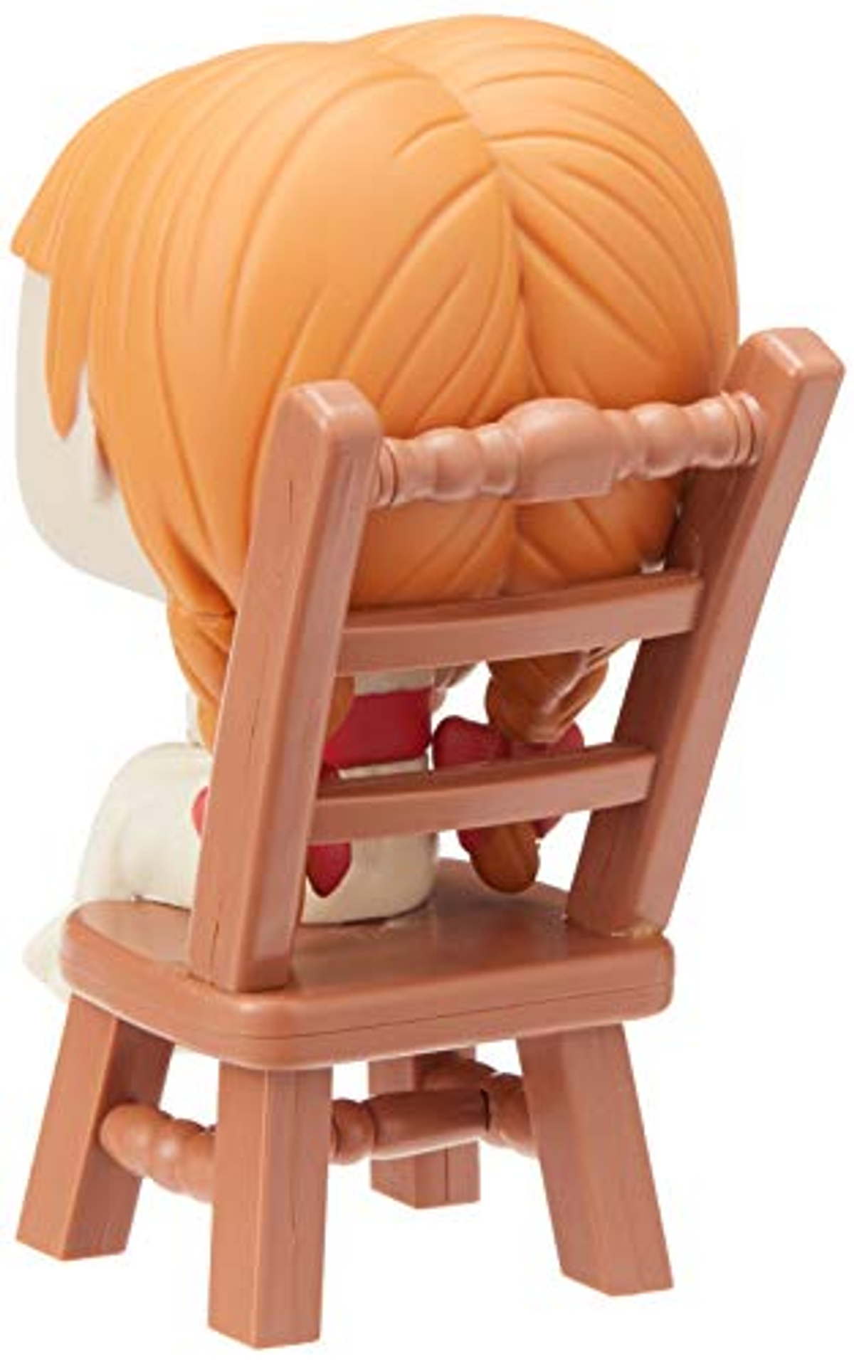 Eine Spielfigur eines Mädchens, das auf einem kleinen Holzstuhl sitzt.