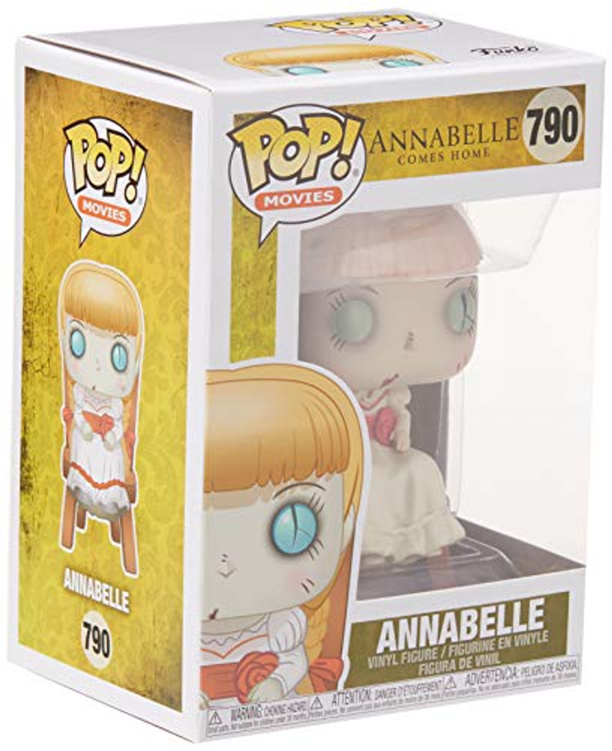 Annabelle-Puppe in einer Box. Die Puppe hat helle Haut, blaue Augen und trägt ein weißes Kleid.