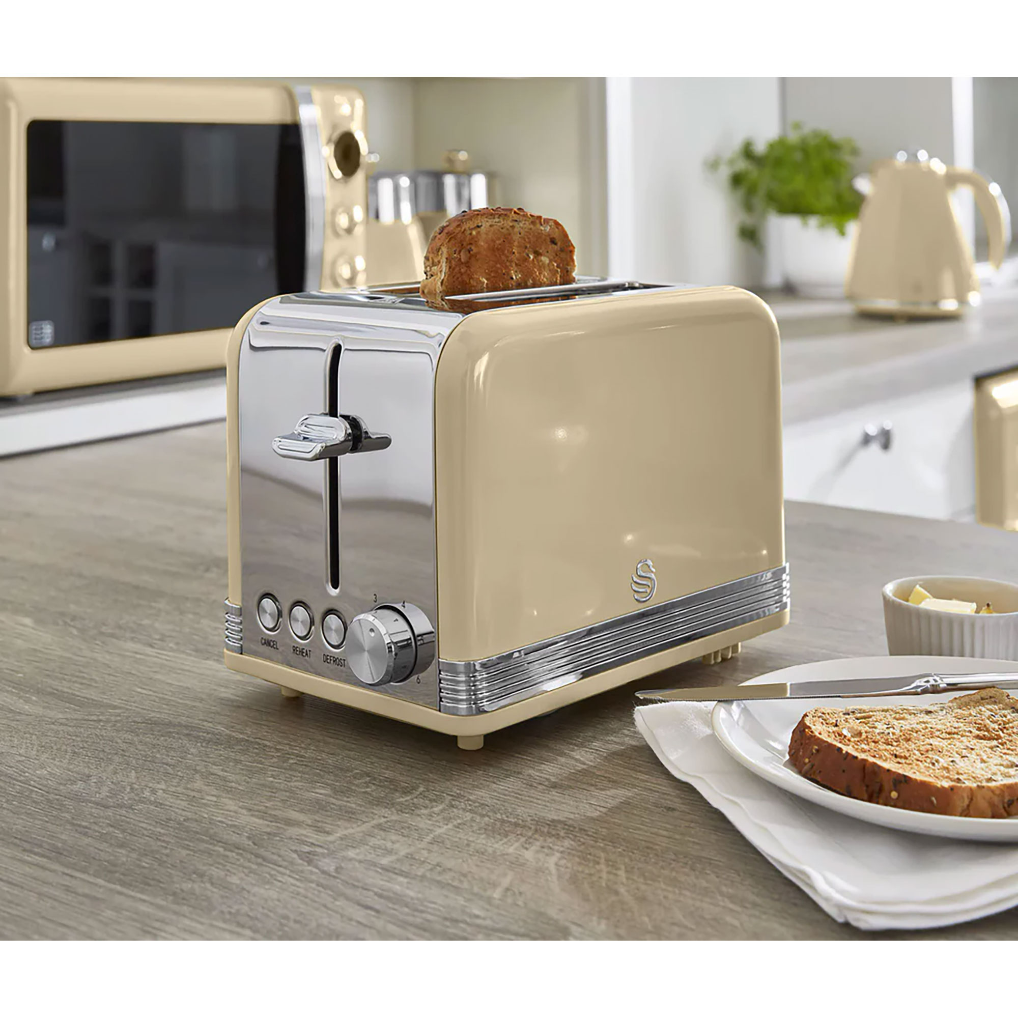 Beiger Toaster mit zwei Schlitzen. Brotscheibe darin, mit Butterplatte und Messer.