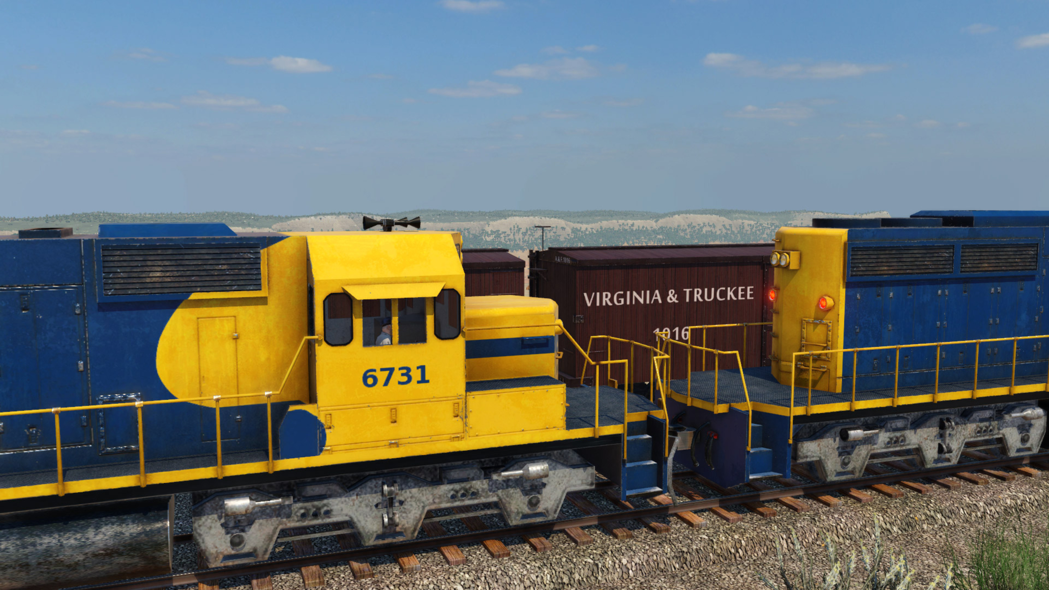 Motore del treno con colori giallo e blu e una carrozza della Virginia & Truckee Railroad.