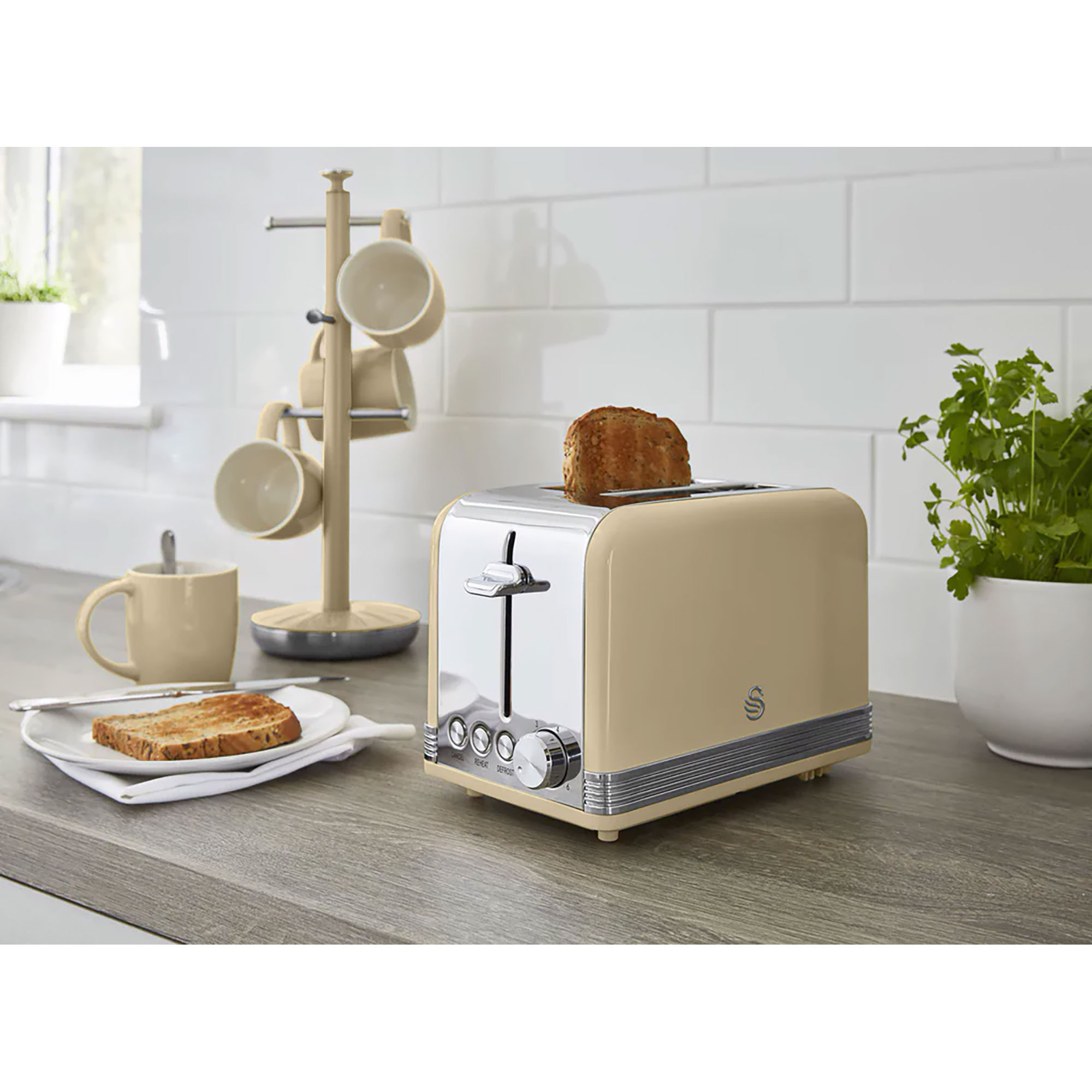 Toaster mit Toast, einer Tasse und einem Tassenregal auf einer Küchentheke.