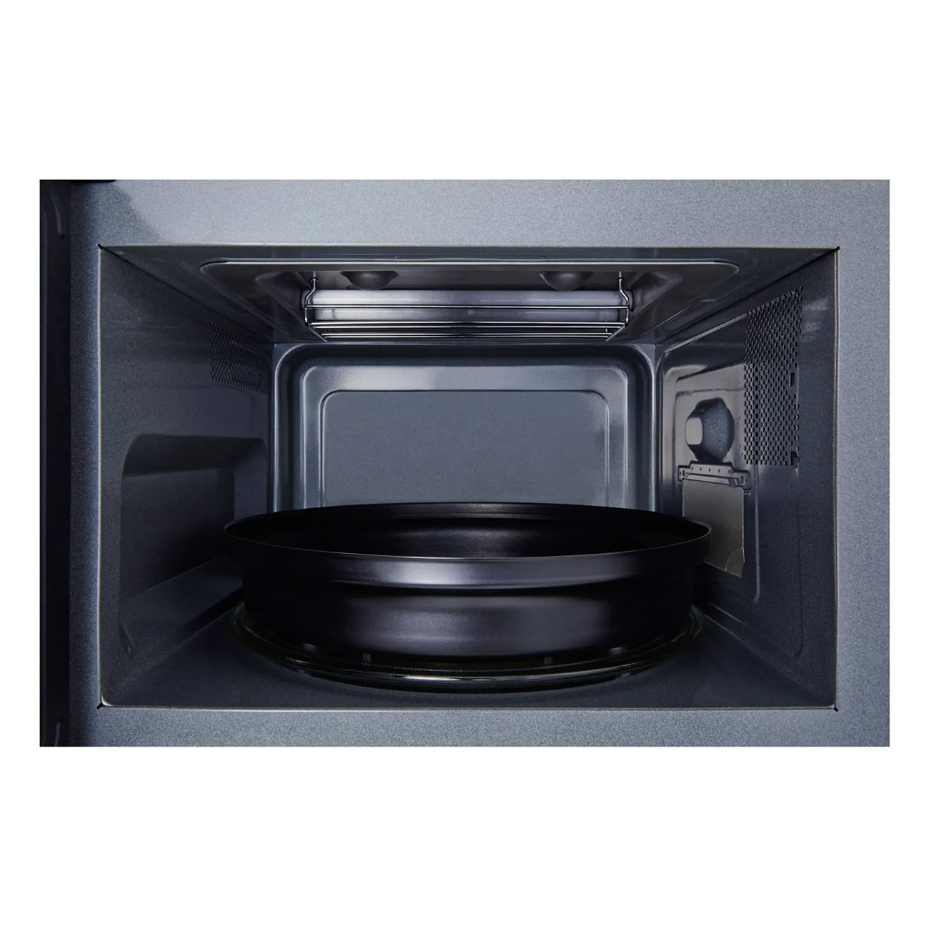 Wnętrze kuchenki mikrofalowej. Czarny, okrągły pojemnik stoi na obrotowym talerzu.