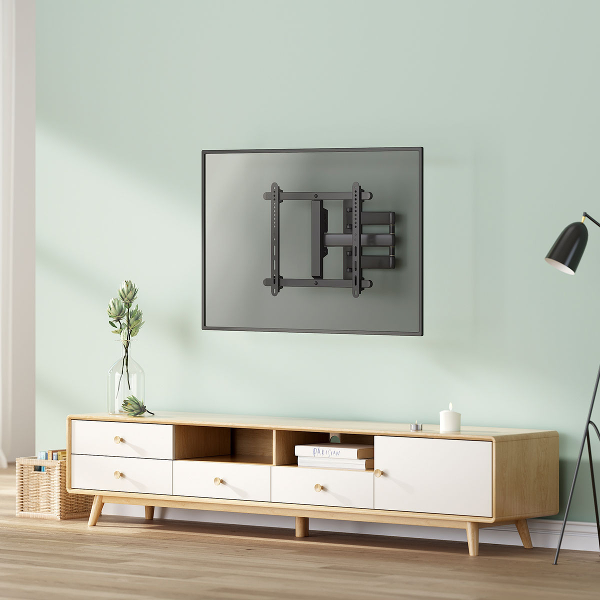 TV mounted on the wall above a wooden cabinet, with decor.
