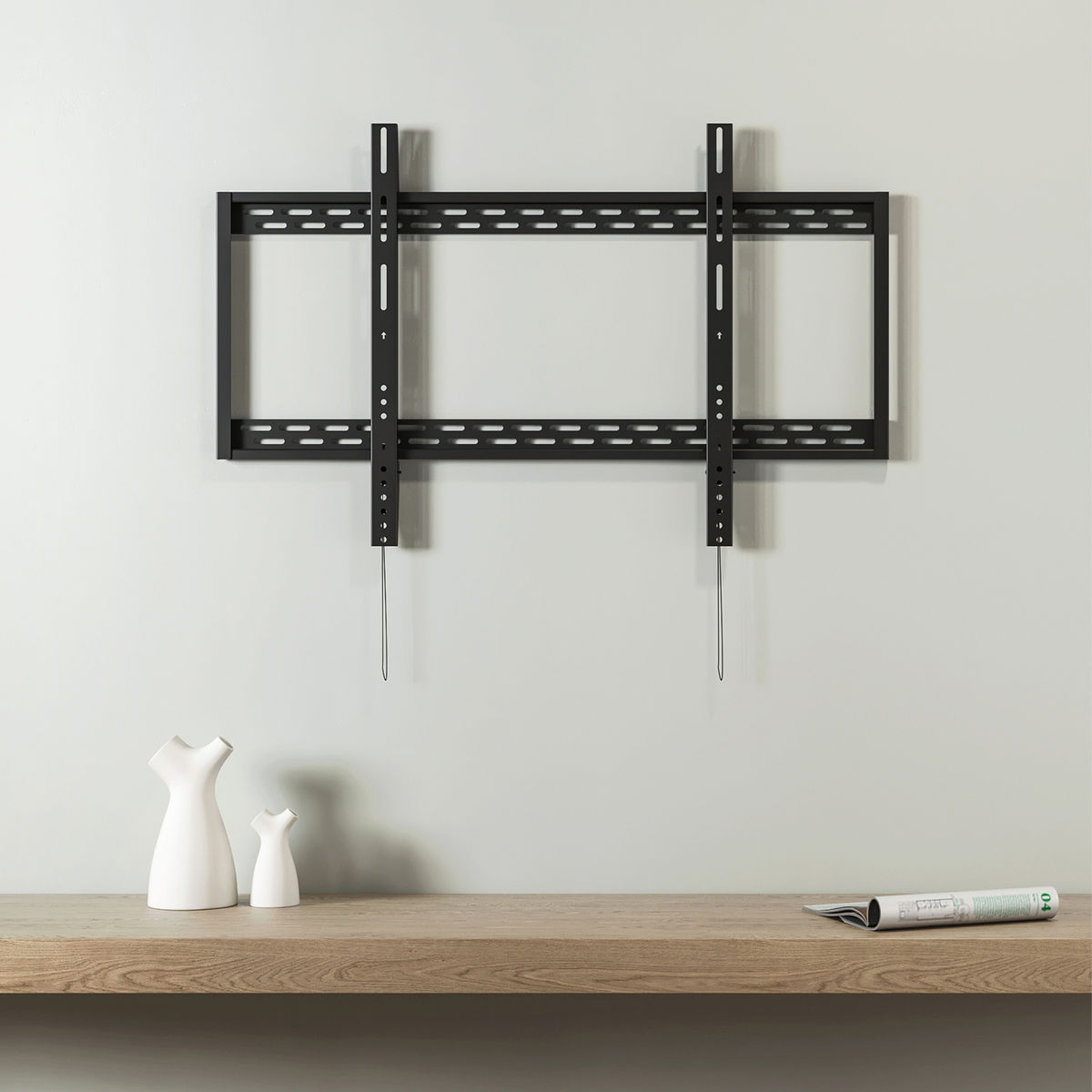Zwarte tv-muurbeugel op een witte muur met een houten plank. Twee vazen en een tijdschrift.