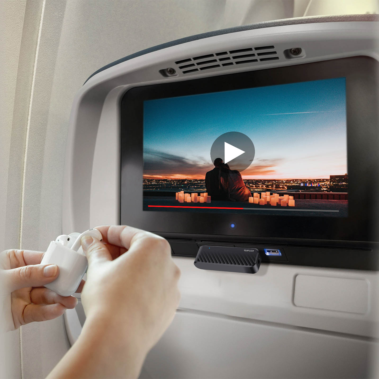 Person hält weiße Ohrhörer neben einem Bildschirm mit einem Video. Hintergrund ist Flugzeuginnenraum.