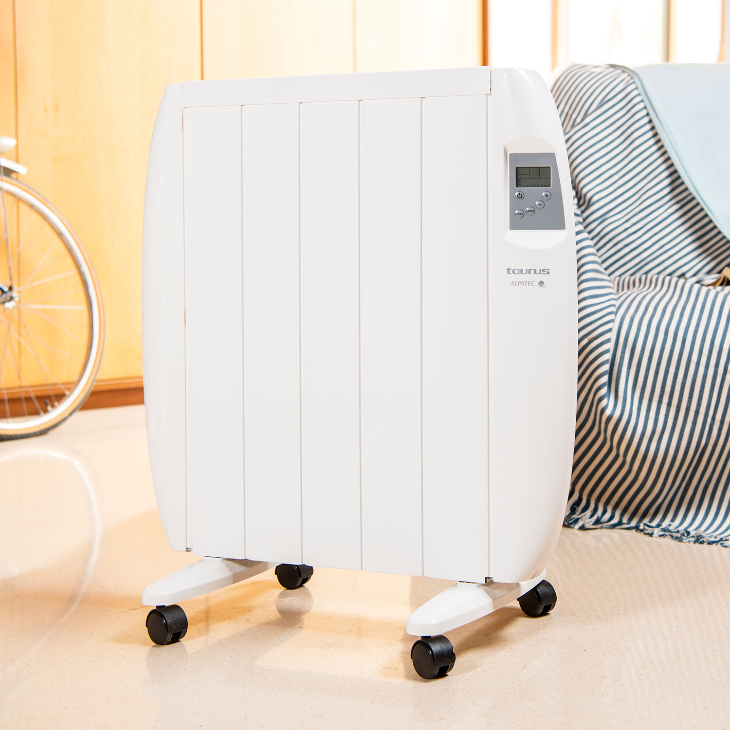 Calentador blanco con ruedas, en una habitación con bicicleta y sofá al fondo.