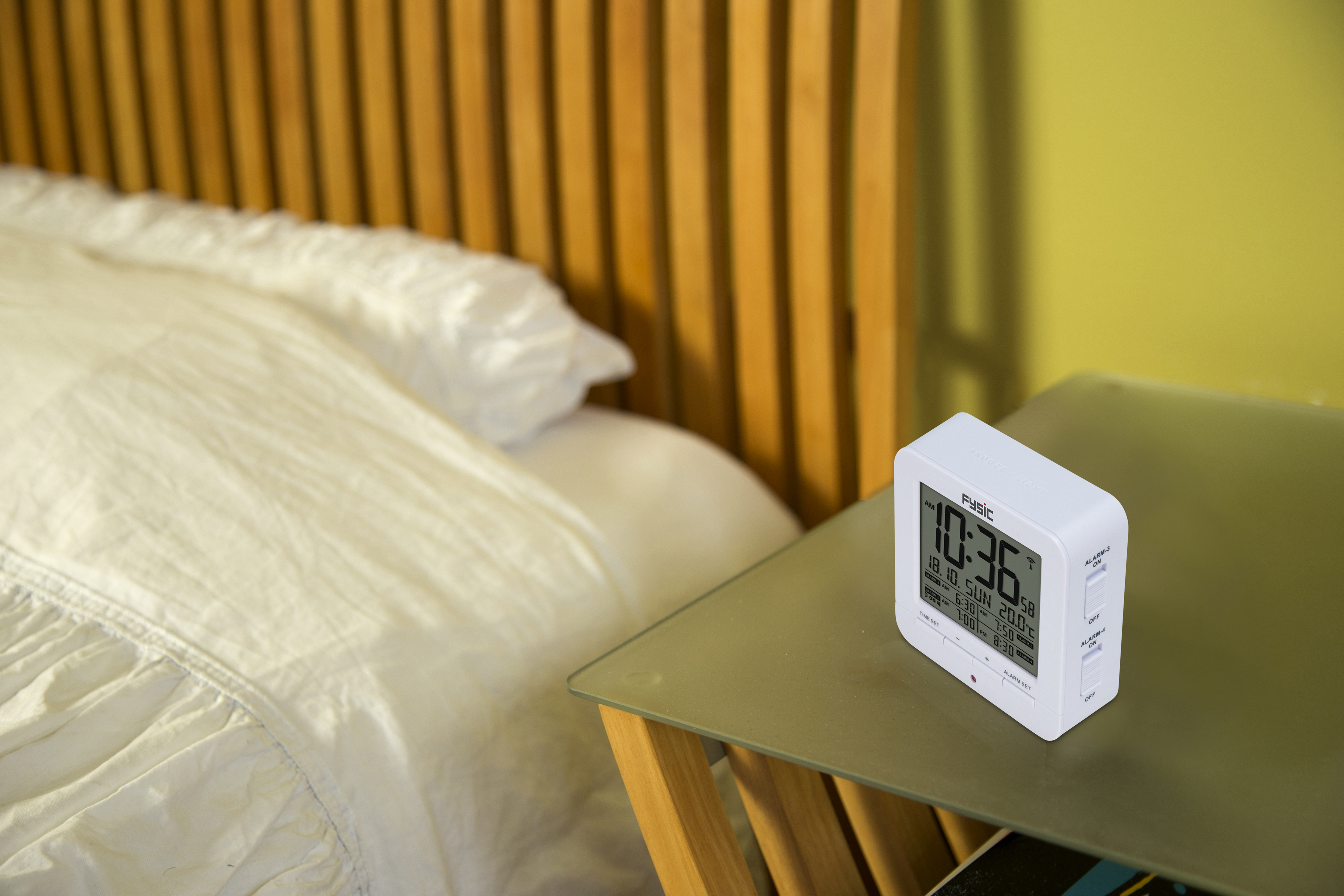 Nachttafereel met een witte klok op een glazen tafel naast een bed met een houten hoofdbord.