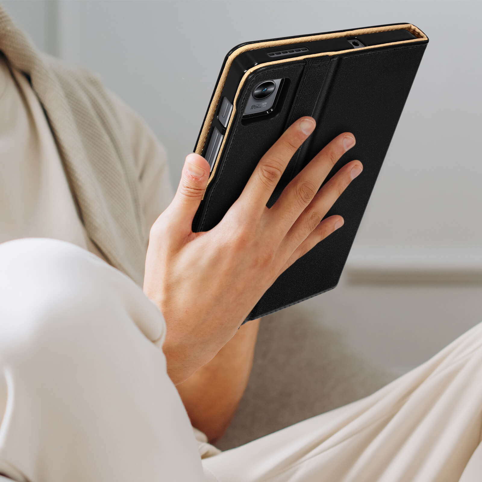 Una persona che tiene una custodia nera con un tablet nero all'interno. Il tablet è nella custodia.