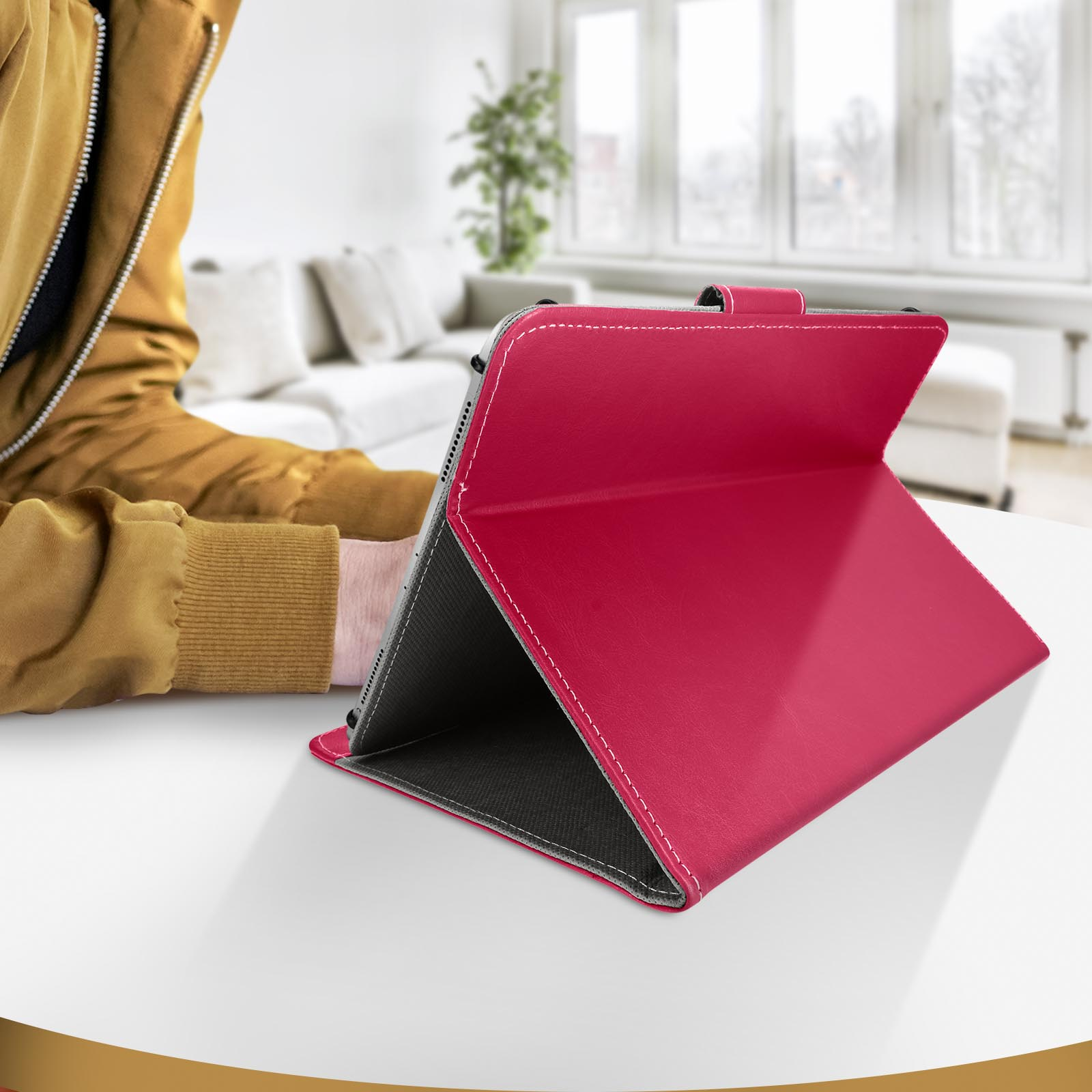 Custodia rossa per tablet aperta su un tavolo bianco. Persona sullo sfondo.